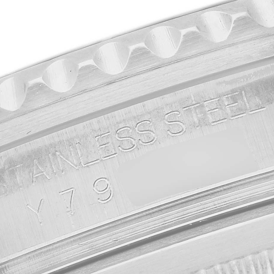 The image shows a close-up of the engraved stainless steel casing of a Rolex GMT-Master model 16710, highlighting part of the bezel and serial number area.