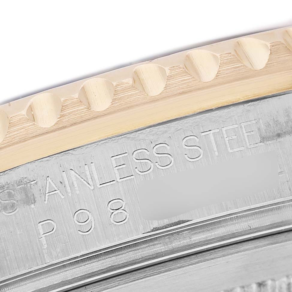 The image shows a close-up of the side of the bezel and the edge with engraved text on the Rolex GMT-Master 16713 Men's Stainless Steel Champagne Dial watch.