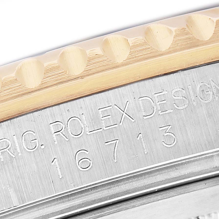 The image shows a close-up of the side of a Rolex GMT-Master 16713 Men's Stainless Steel Champagne Dial watch, focusing on the engraved model number and part of the bezel.