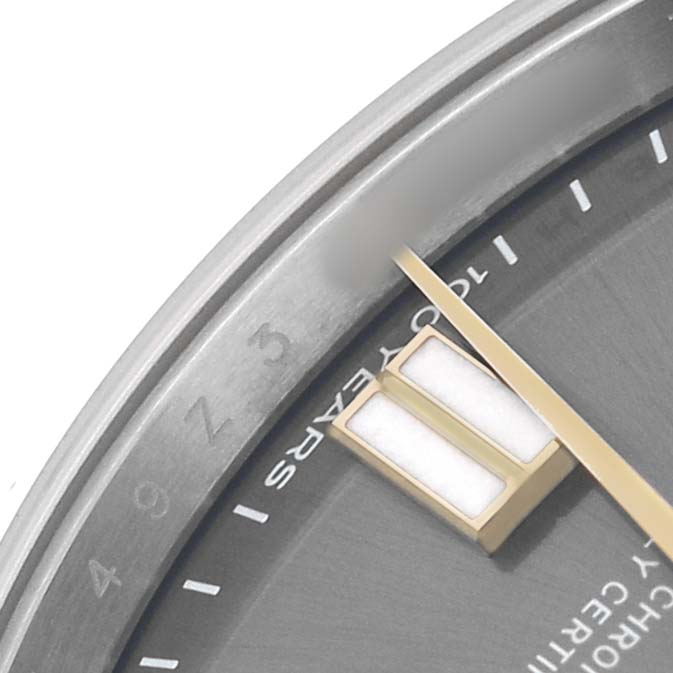 The image shows a close-up of the Rolex Oyster Perpetual 134303 Men's Stainless Steel Grey Dial watch face, featuring the hands, markers, and partial bezel.