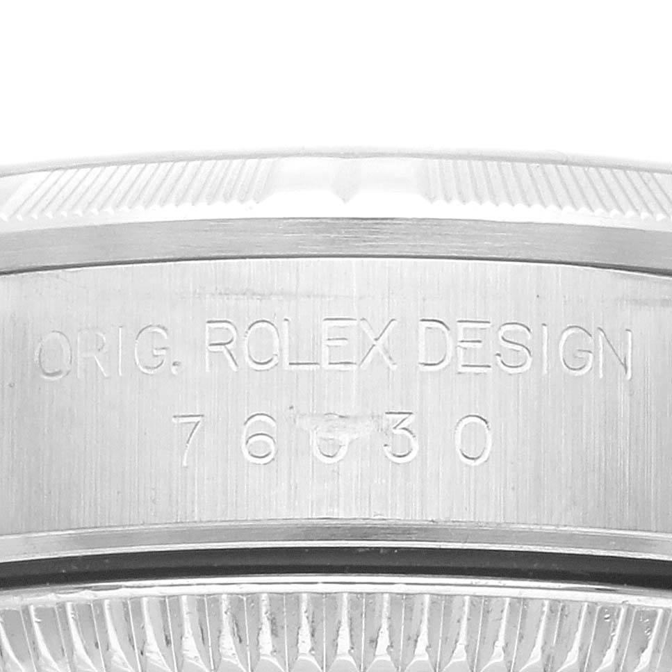 This image shows an angled close-up of the case side and part of the bezel of a Rolex Oyster Perpetual 76030 Women's Stainless Steel Pink Dial 76030 Women's Stainless Steel Pink Dial watch, displaying its engraving.