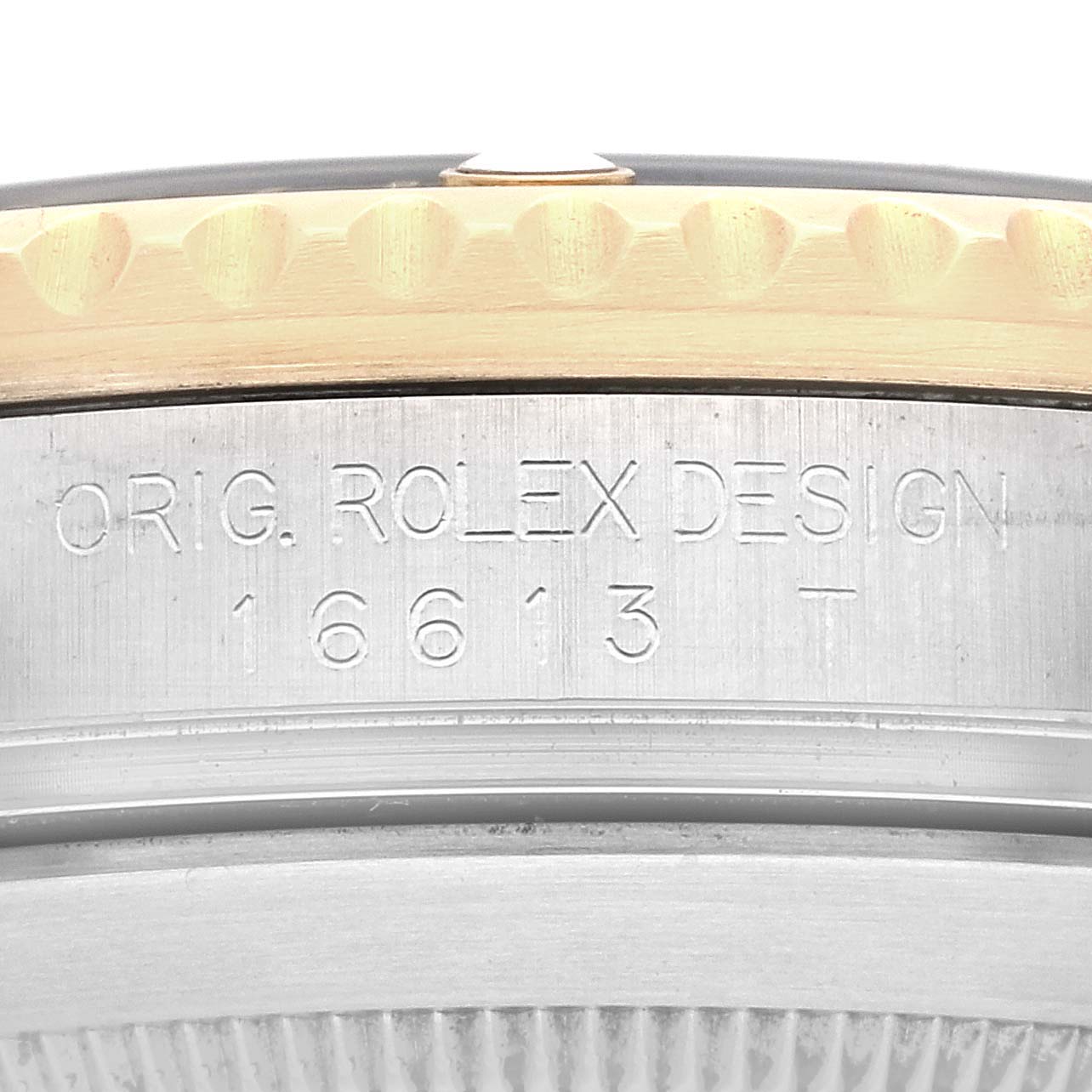 This image shows a close-up of the side of a Rolex Submariner 16613 Men's Steel and Gold (two tone) Black Dial 16613 Men's Steel and Gold (two tone) Black Dial model 16613, displaying etched text and the bezel.