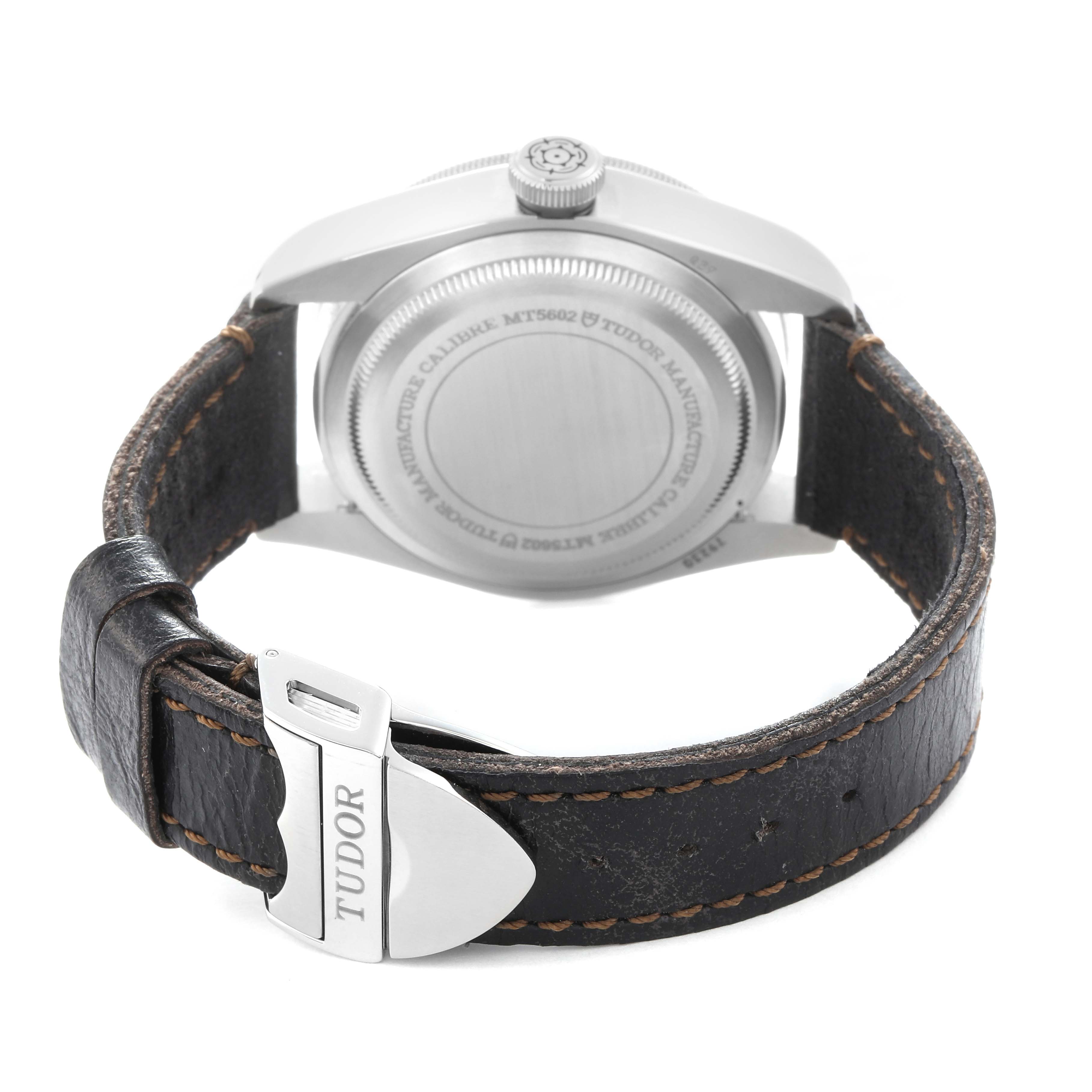 The image shows the back case and strap of a Tudor Heritage Black Bay, model number 79230R, emphasizing the clasp and stitching on the leather strap.