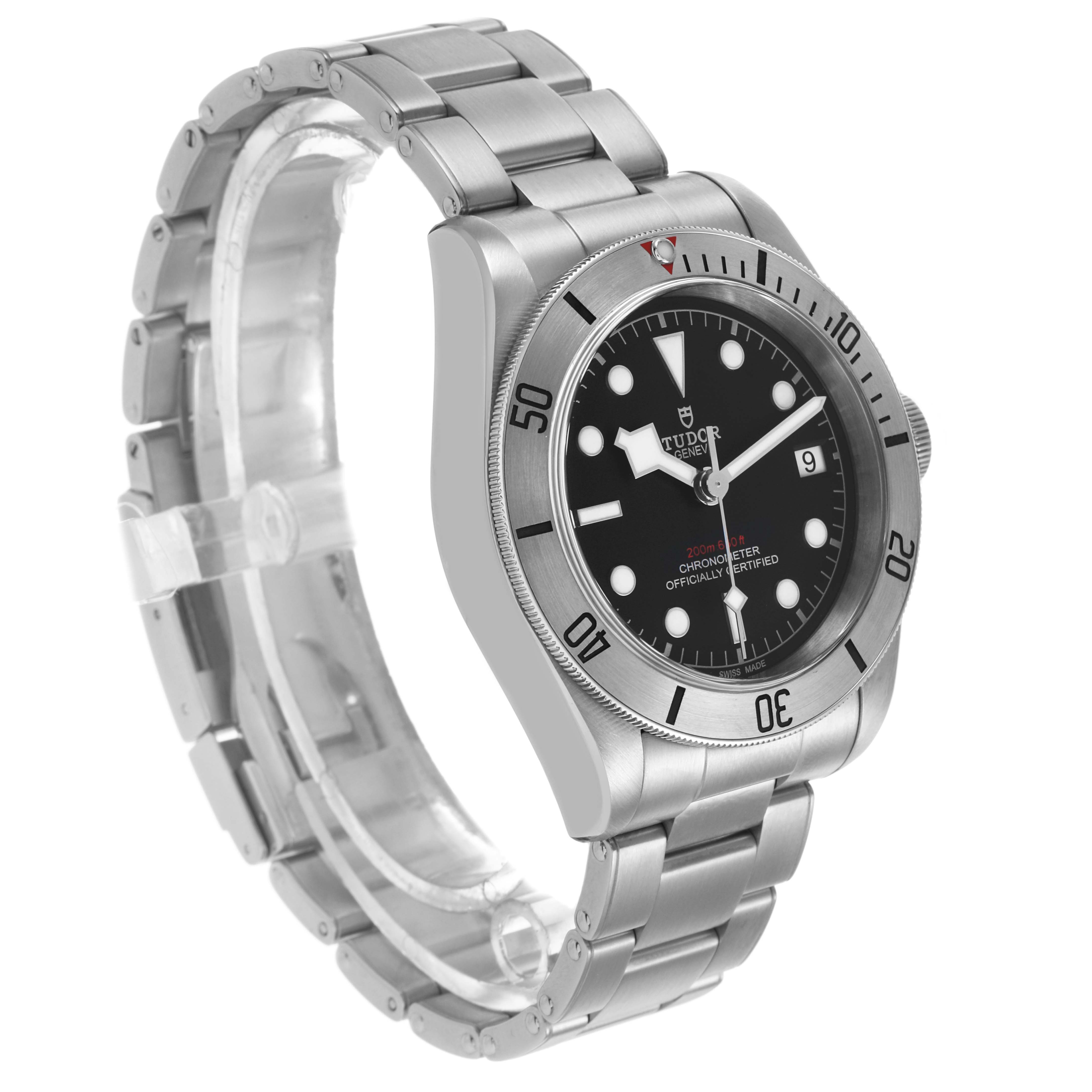 The Tudor Heritage Black Bay M79730-003 Men's Stainless Steel Black Dial watch is shown at an angle highlighting the face, bezel, and stainless steel bracelet.