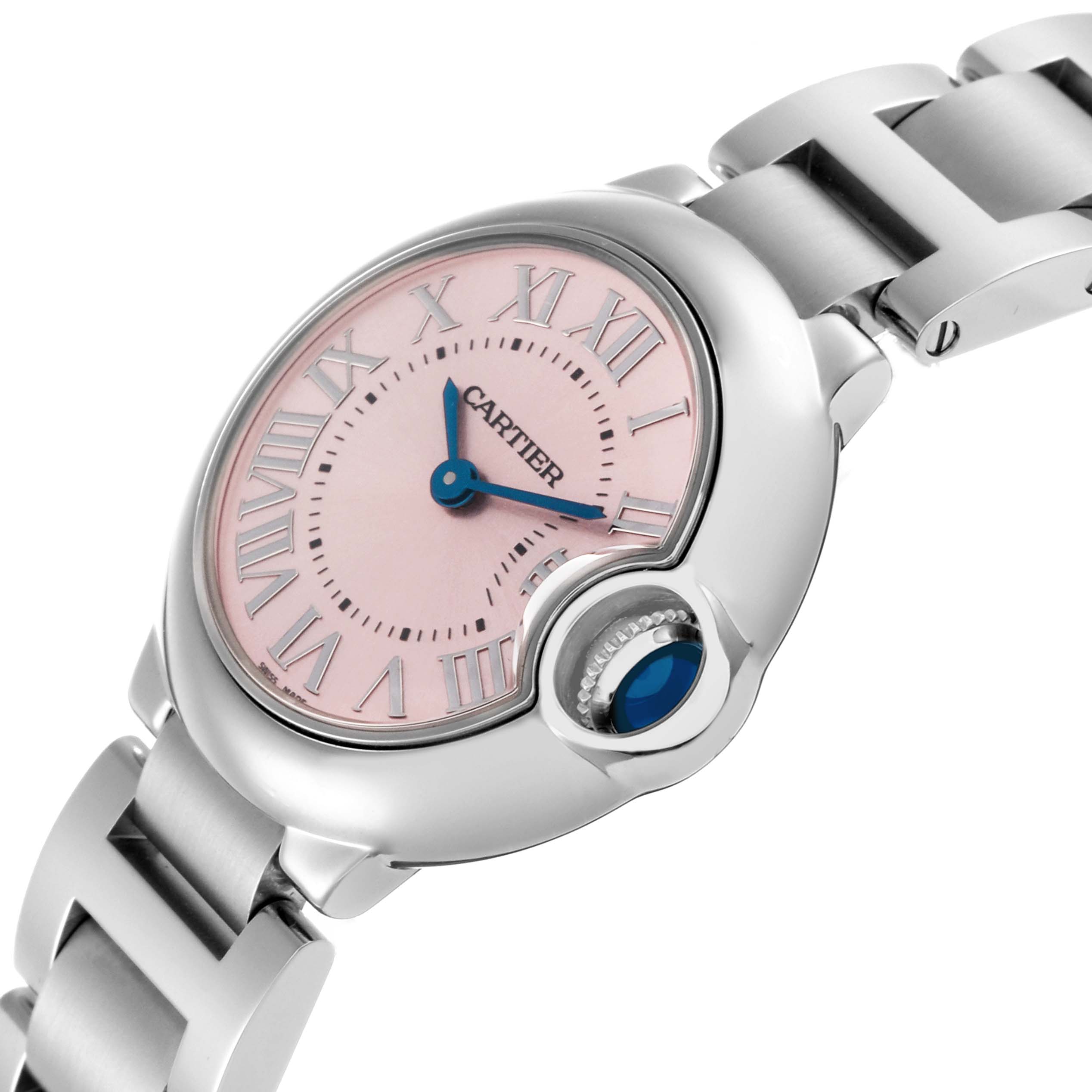 The Cartier Ballon Bleu watch, model W6920038, is shown at a side angle highlighting its pink dial, blue hands, crown with sapphire cabochon, and bracelet.