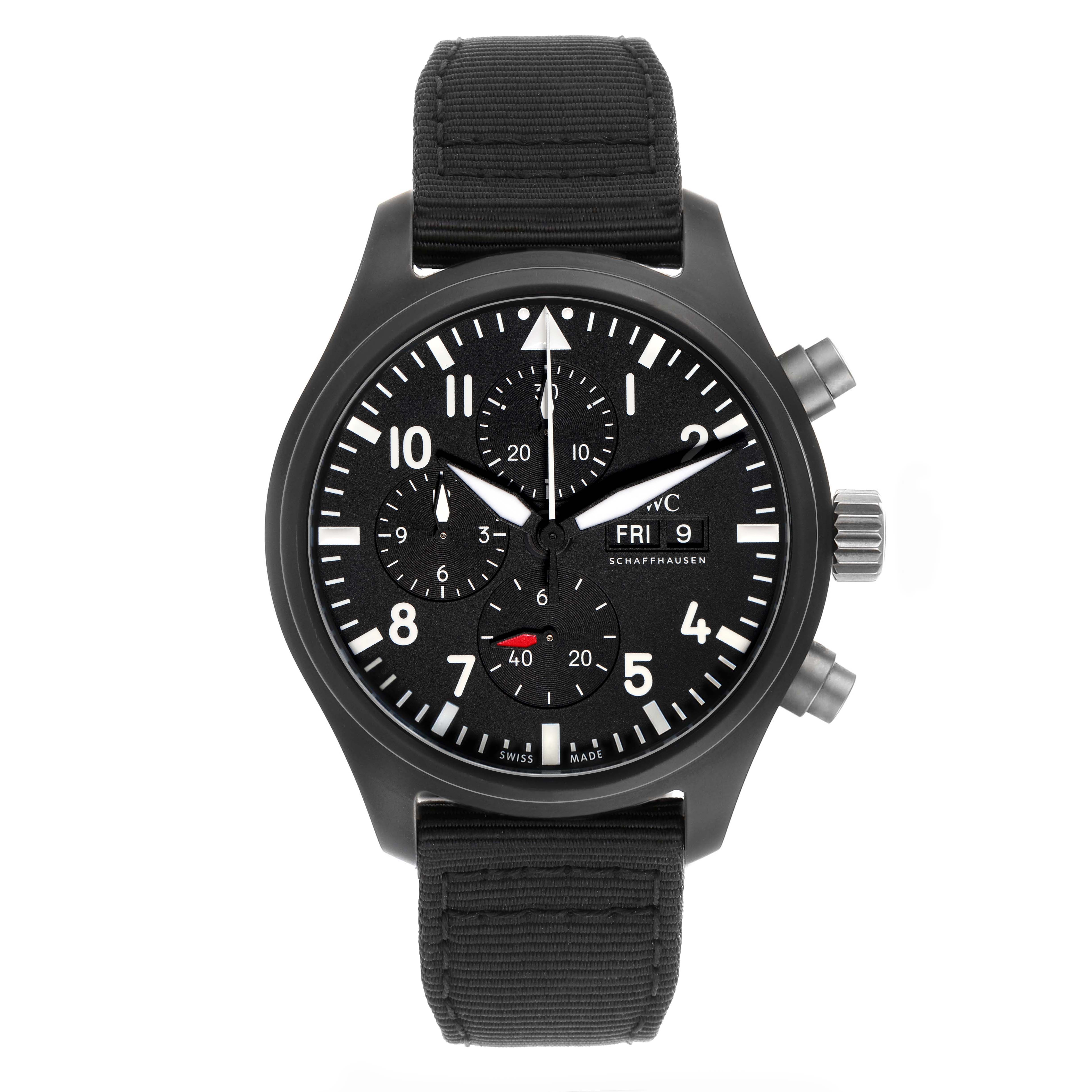 The IWC Pilot model IW389101 watch is shown from a front angle, highlighting the black dial, white markers, chronograph subdials, and a fabric strap.