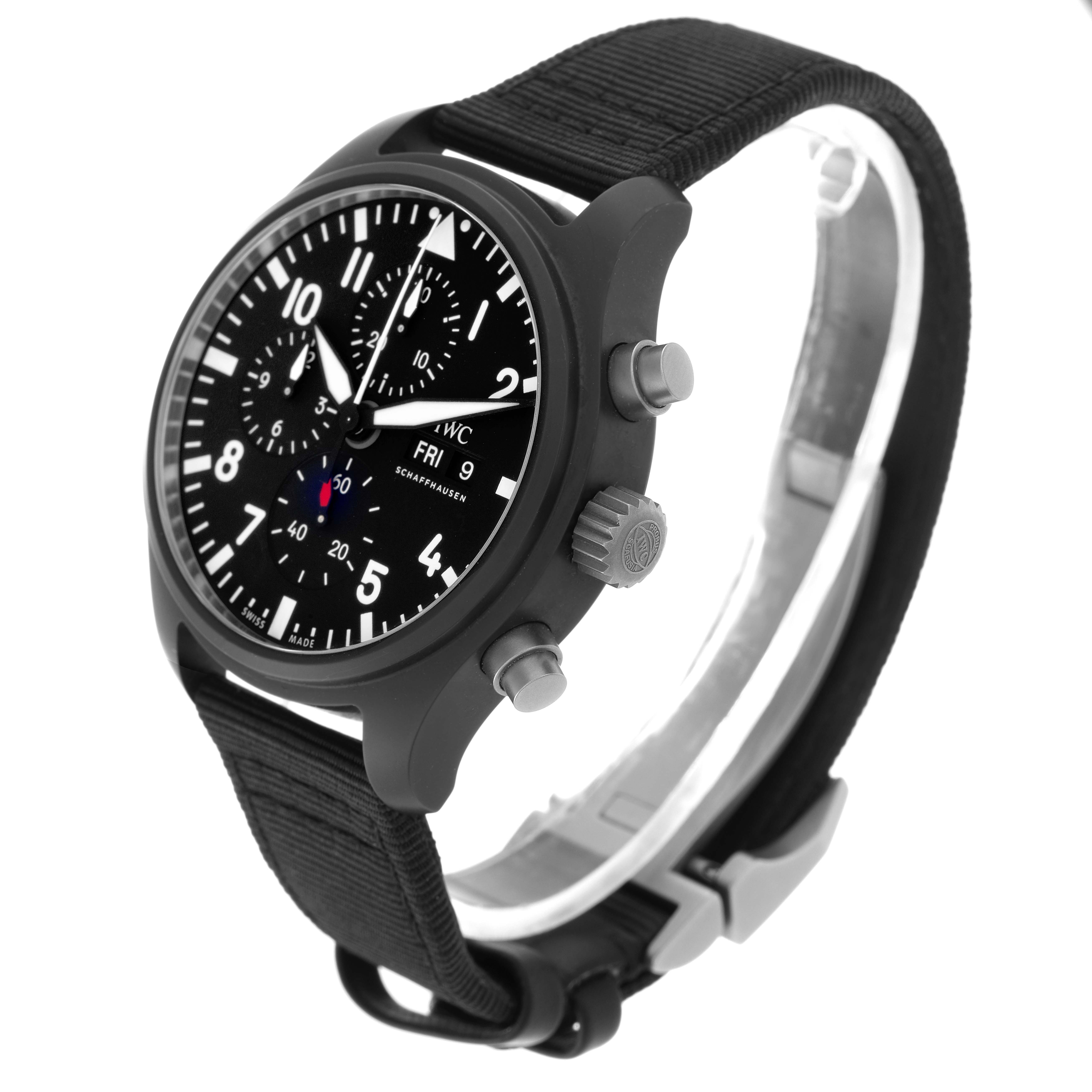 The IWC Pilot model IW389101 watch is shown at a three-quarter angle, highlighting the face, side crown, pushers, and fabric strap with buckle.