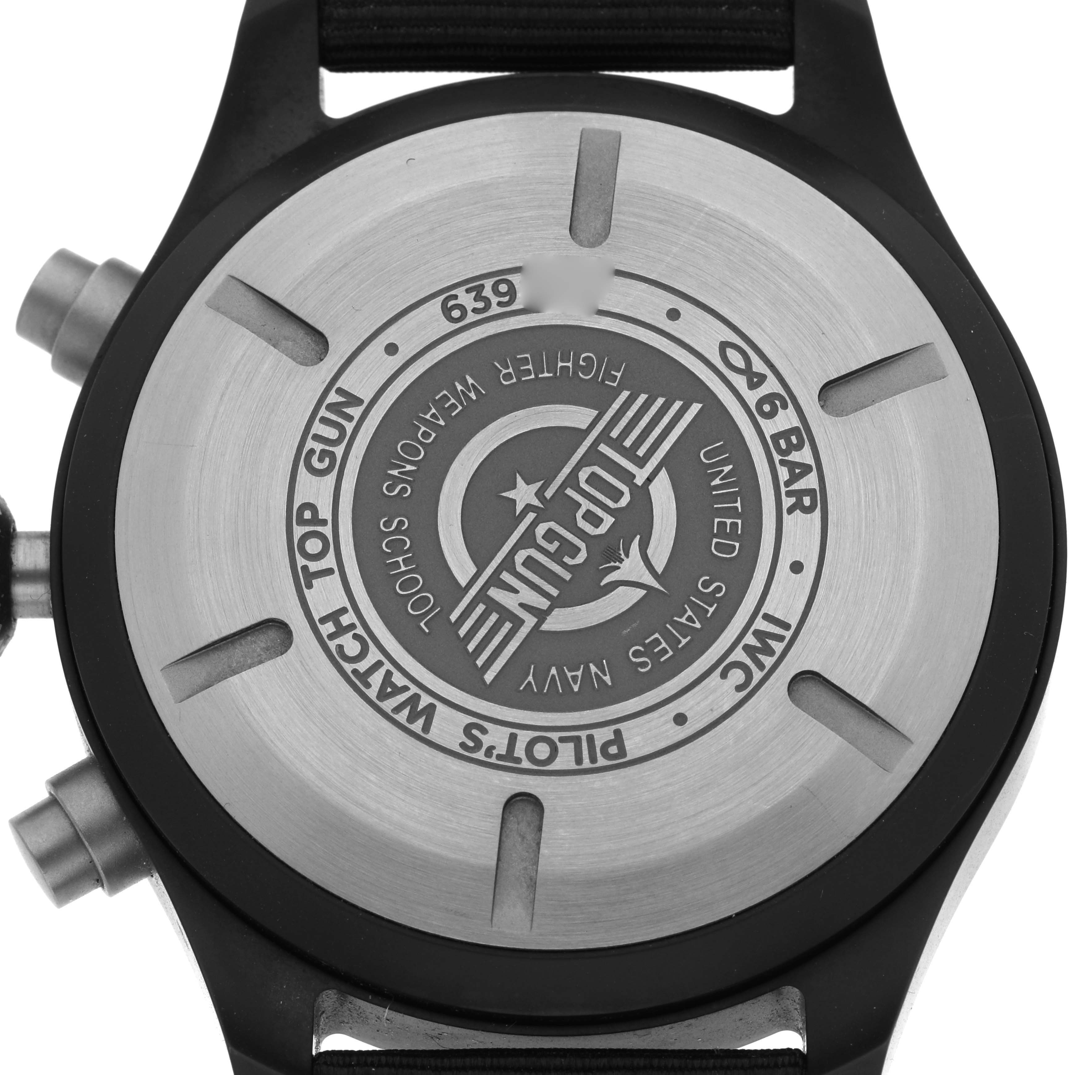 The image shows the case back of the IWC Pilot model IW389101 watch, featuring engraving details and part of the strap and pushers visible from the back angle.