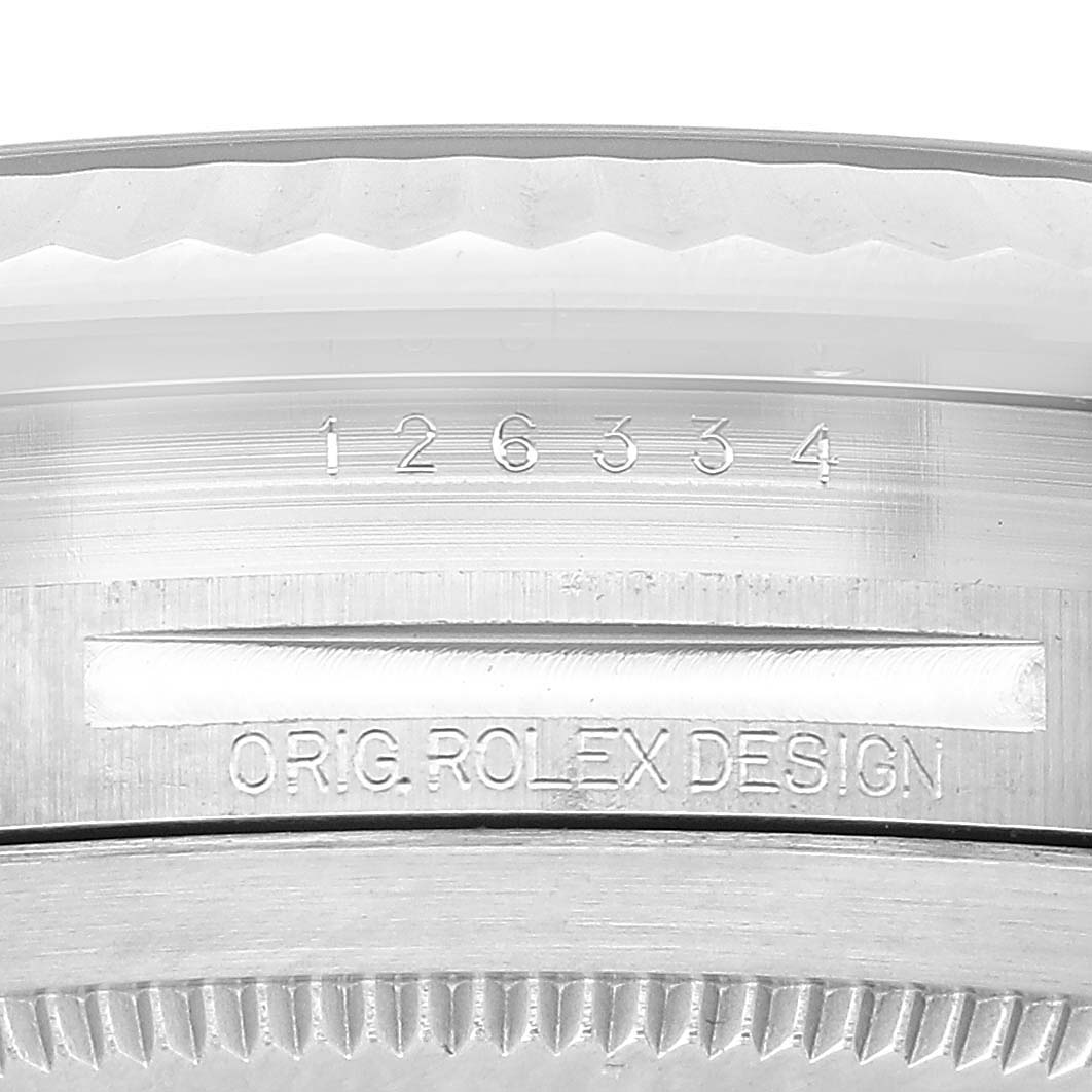 The image shows a close-up of the side of a Rolex Datejust 41 126334 Men's Stainless Steel Blue Dial, featuring engravings and part of the bezel.