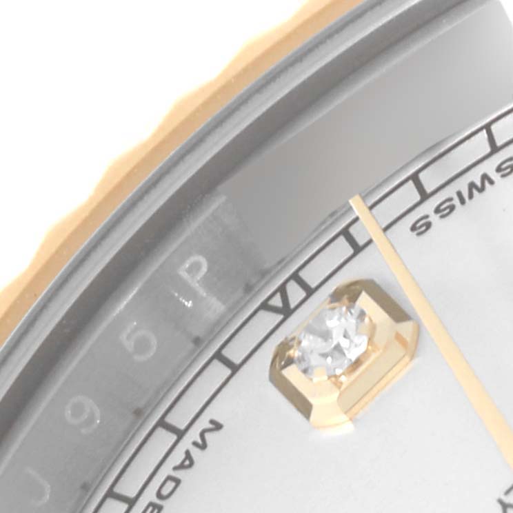 This close-up image of a Rolex Datejust watch showcases part of the dial, a diamond hour marker, and the edge of the bezel.