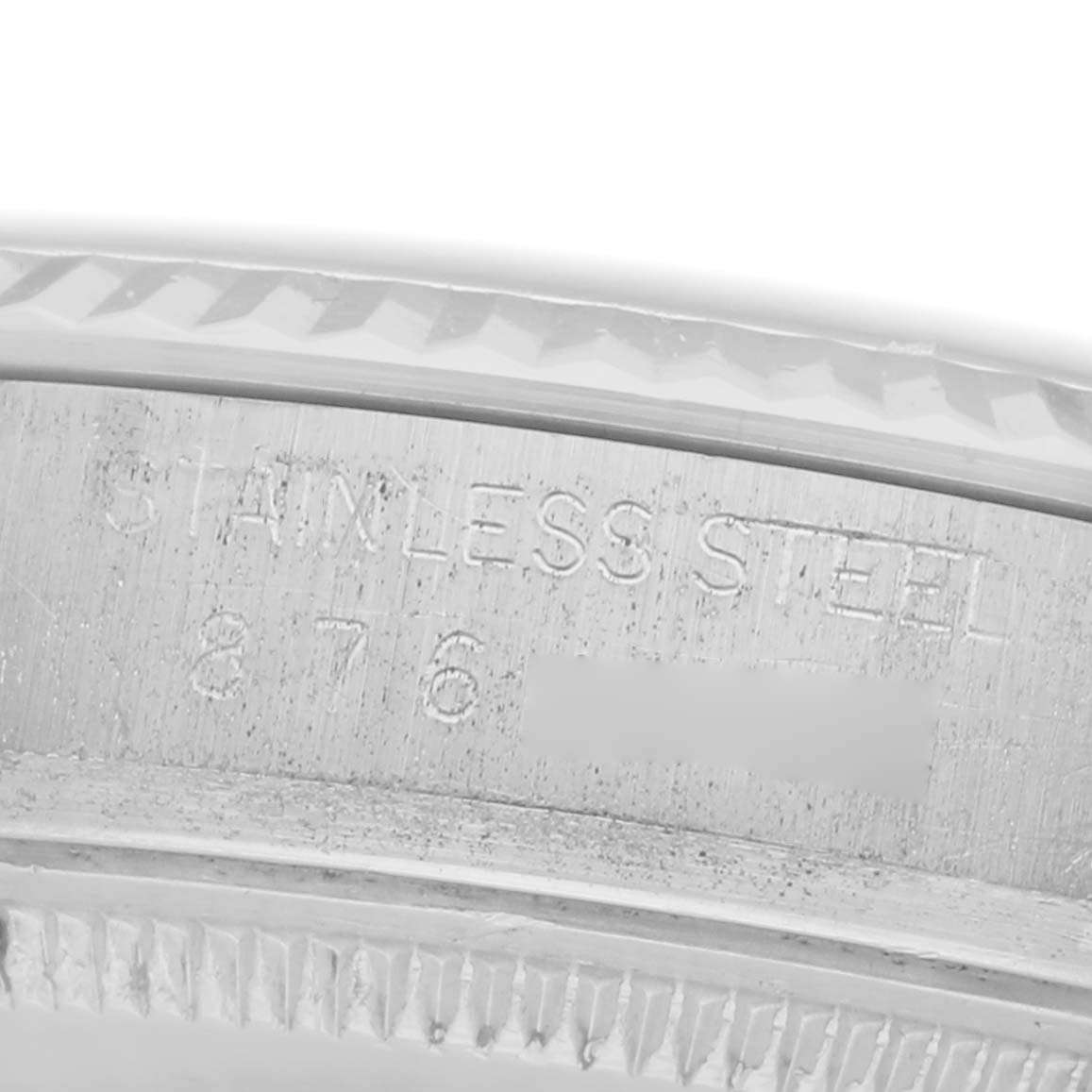 The image shows a close-up of the edge of a Rolex Vintage Collection model 16014 men's watch, focusing on the stainless steel part with engraved text.