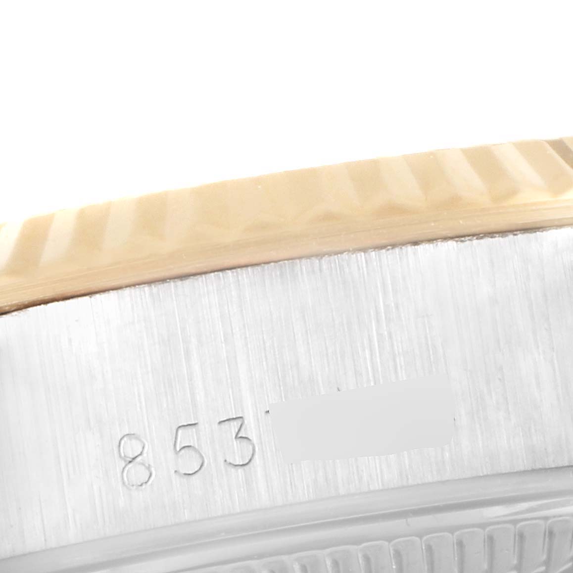 This image shows a close-up of the side of the bezel and case of a Rolex Datejust 69173 Women's Steel and Gold (two tone) Champagne Dial 69173 Women's Steel and Gold (two tone) Champagne Dial watch, highlighting engravings.