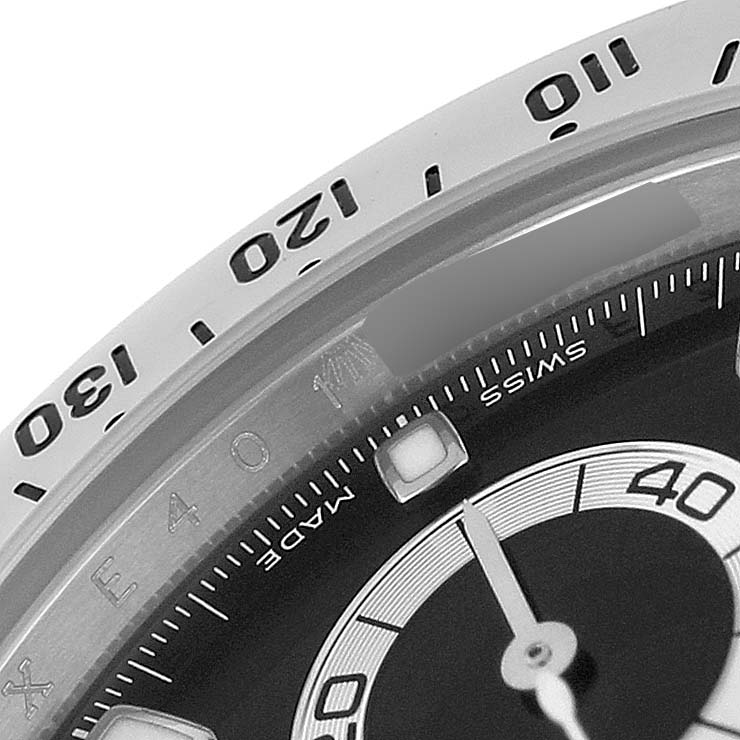 The image shows a close-up of the Rolex Daytona 116520 Men's Stainless Steel Black Dial's bezel and part of the dial, highlighting the tachymetric scale and subdial.
