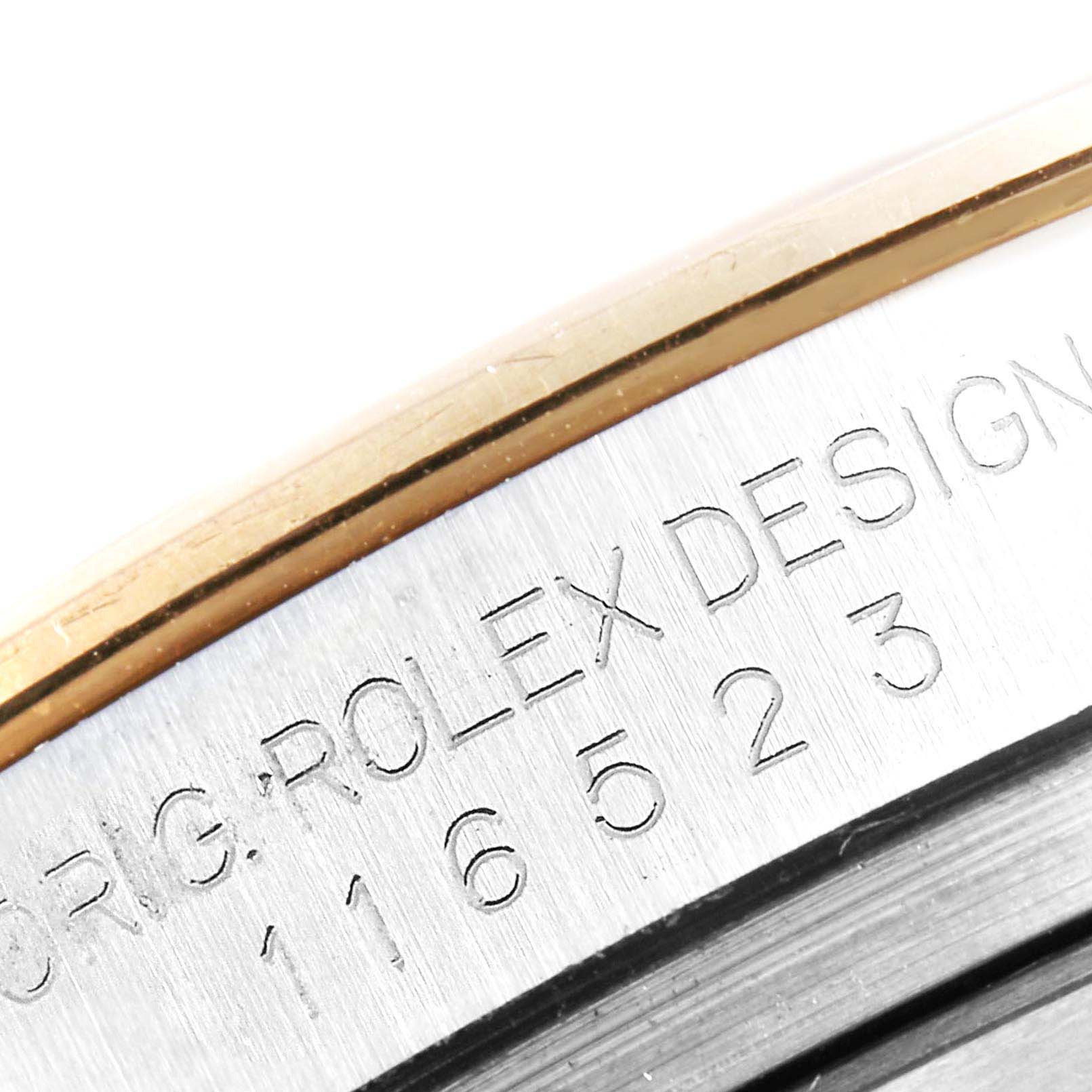 The image shows a close-up angle of the side of a Rolex Daytona 116523 Men
s Steel and Gold (two tone) Black Dial 116523 Men
s Steel and Gold (two tone) Black Dial watch, focusing on the engraved model number and "Rolex Design" text.