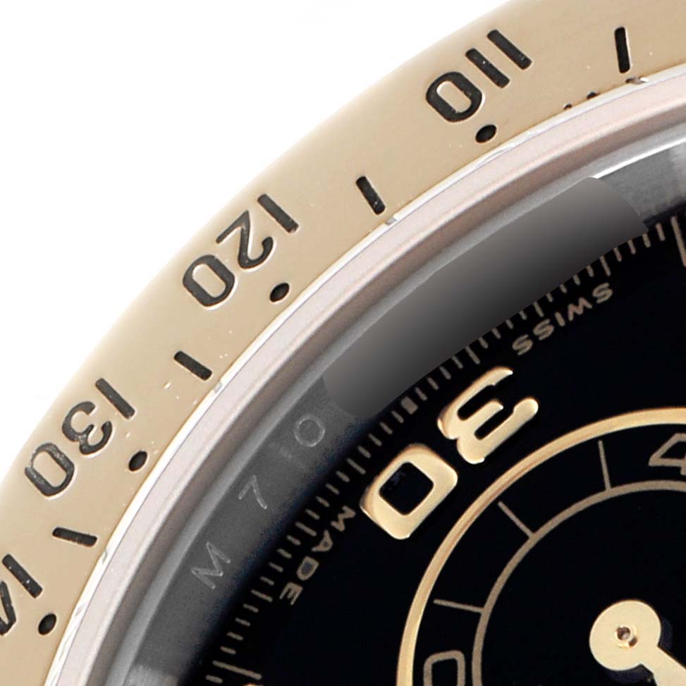 The image shows a partial view of the bezel and dial of the Rolex Daytona model 116523 men's watch, highlighting the minute markers and tachymetric scale.