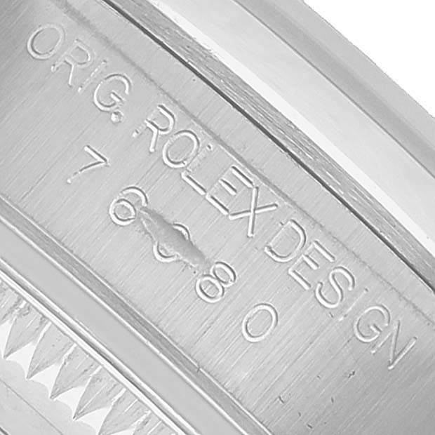 The image shows a close-up of the side of the bezel and case edge of a Rolex Oyster Perpetual 76080 Men's Stainless Steel Pink Dial, featuring engraved details.