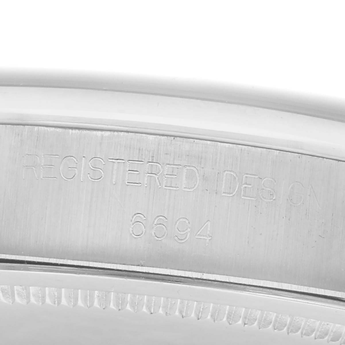 The image shows the side engraving on the case of a Rolex Date, model 6694, displaying the model number.