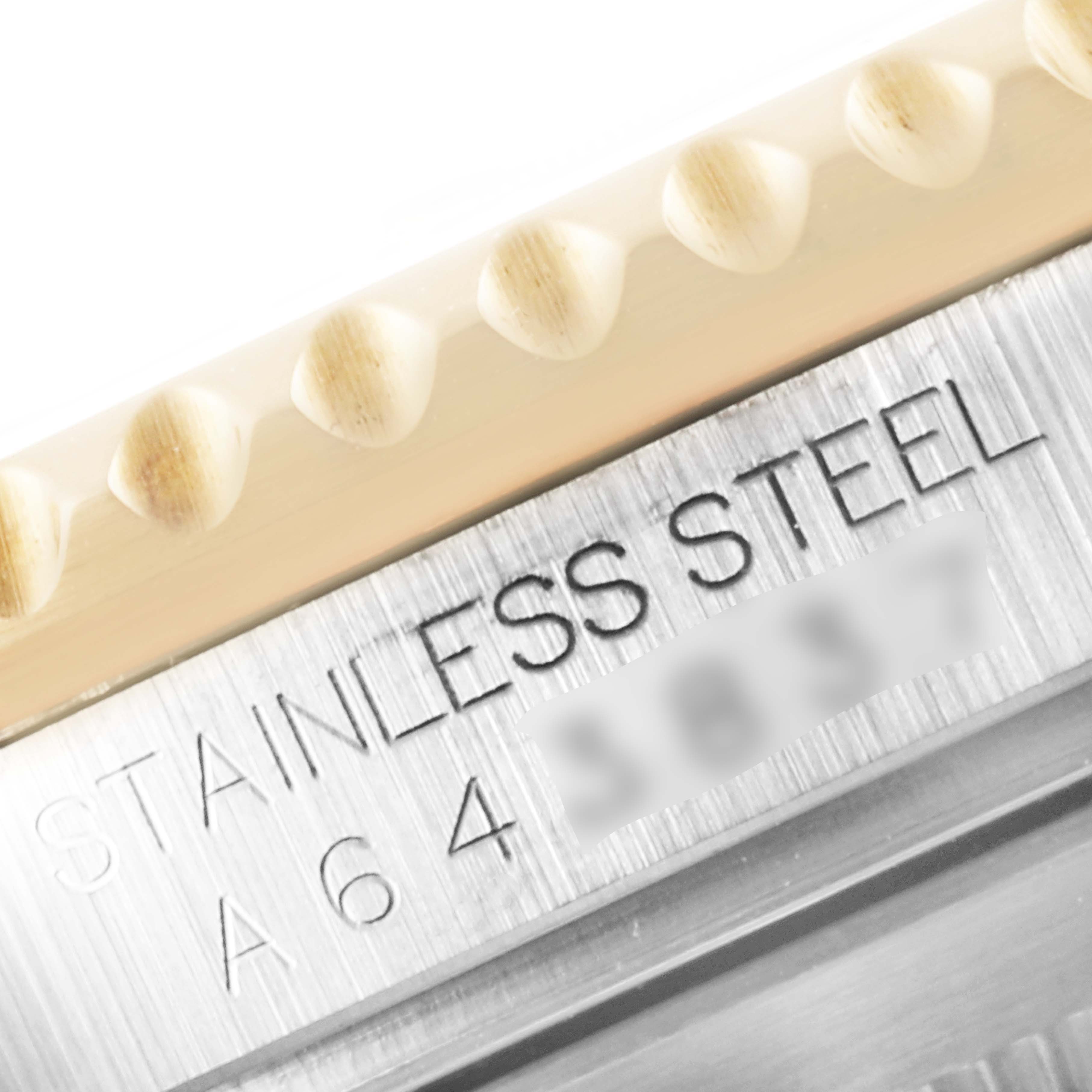 This close-up image of the Rolex Submariner 16613 Men's Steel and Gold (two tone) Blue Dial 16613 Men's Steel and Gold (two tone) Blue Dial shows a portion of the bezel and the stainless steel case with engraved text.