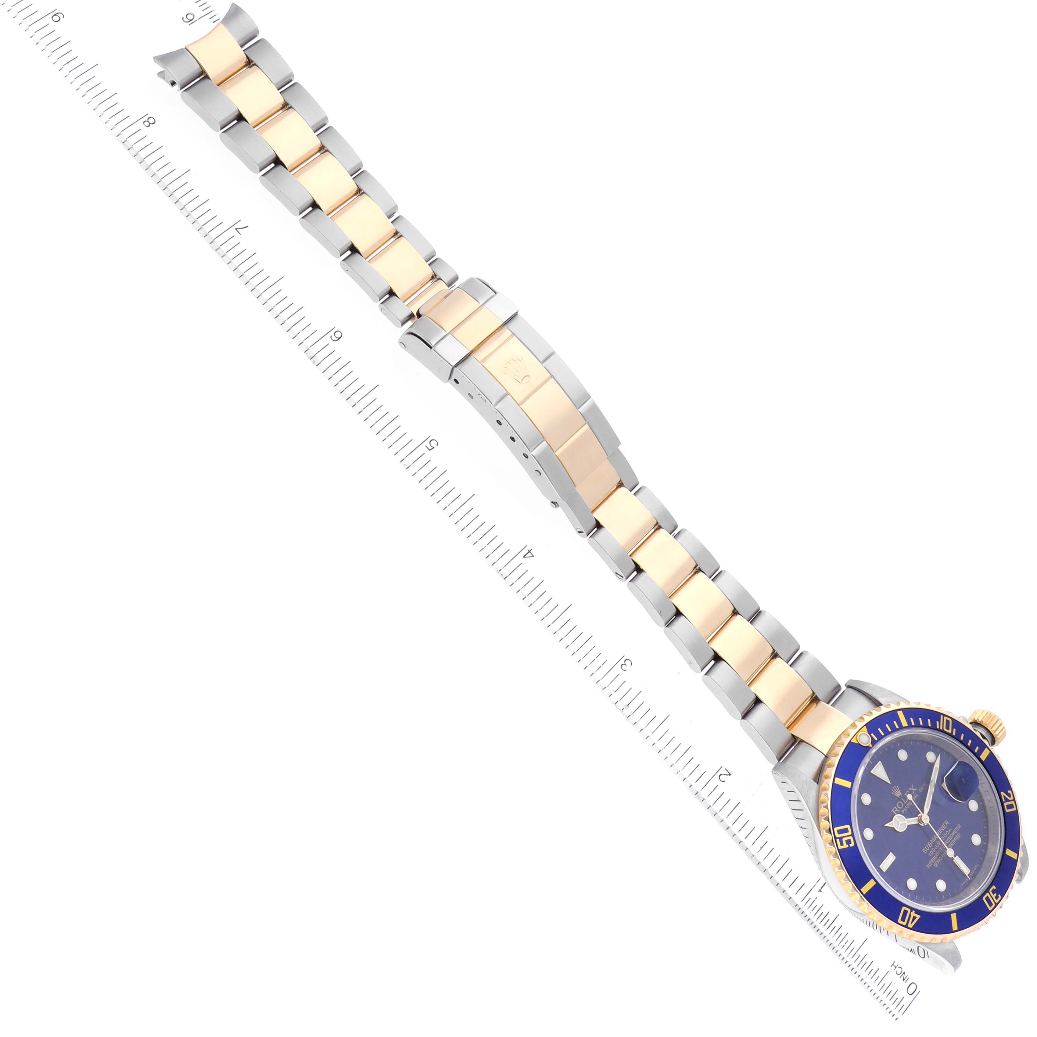 The Rolex Submariner 16613 Men's Steel and Gold (two tone) Blue Dial 16613 Men's Steel and Gold (two tone) Blue Dial watch is shown at an angle, displaying the dial, bezel, crown, and full bracelet with a ruler for scale.