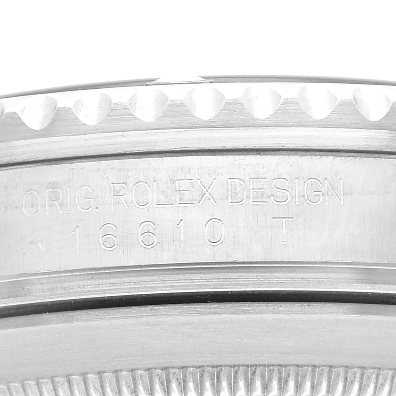 The image shows a close-up of the case side of a Rolex Submariner 16610 Men
s Stainless Steel Black Dial 16610 Men
s Stainless Steel Black Dial, detailing the engravings "ORIG ROLEX DESIGN 16610 T."