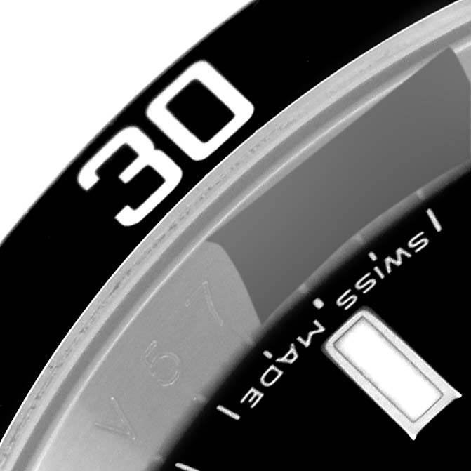 The image shows a close-up angle of the Rolex Submariner 16610 Men
s Stainless Steel Black Dial 16610 Men
s Stainless Steel Black Dial watch bezel and a portion of the dial with the text "Swiss Made."