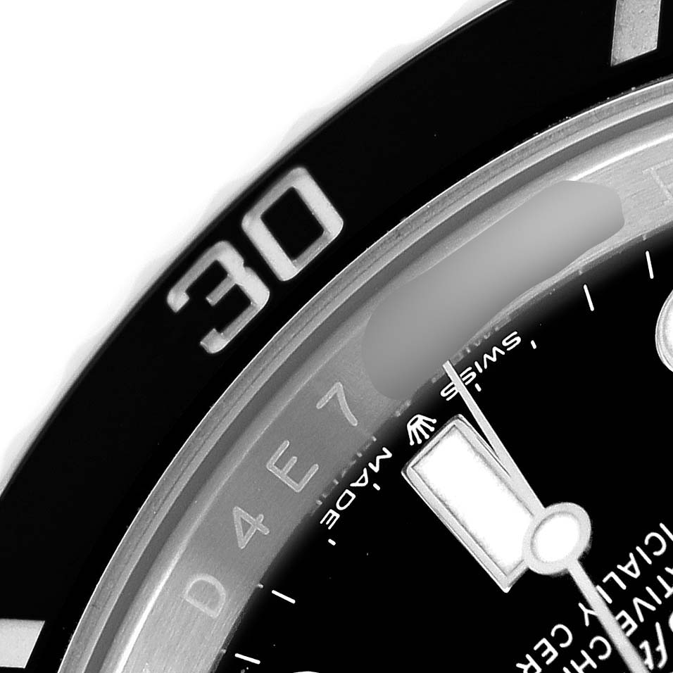 The image shows a close-up of a Rolex Submariner M124060-0001 Men's Stainless Steel Black Dial, focusing on the bezel, dial, and part of the hour hand.