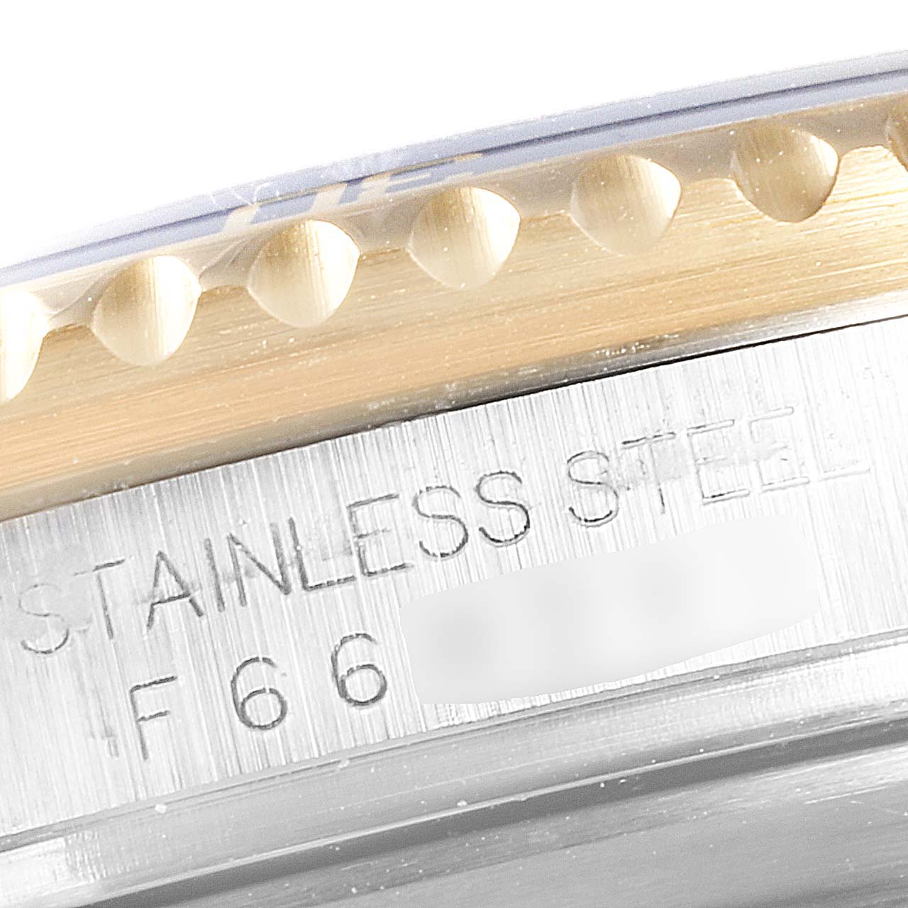 Close-up of the side of the bezel and case of a Rolex Submariner 16613 Men
s Steel and Gold (two tone) Grey Dial 16613 Men
s Steel and Gold (two tone) Grey Dial watch, showing 
STAINLESS STEEL
 engraving.