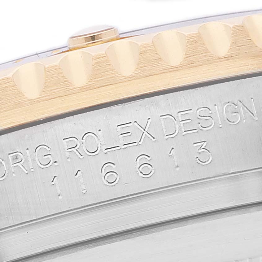 This close-up image shows the side of the Rolex Submariner 116613 Men
s Steel and Gold (two tone) Black Dial 116613 Men
s Steel and Gold (two tone) Black Dial model, focusing on the watch
s bezel and engraved serial number.