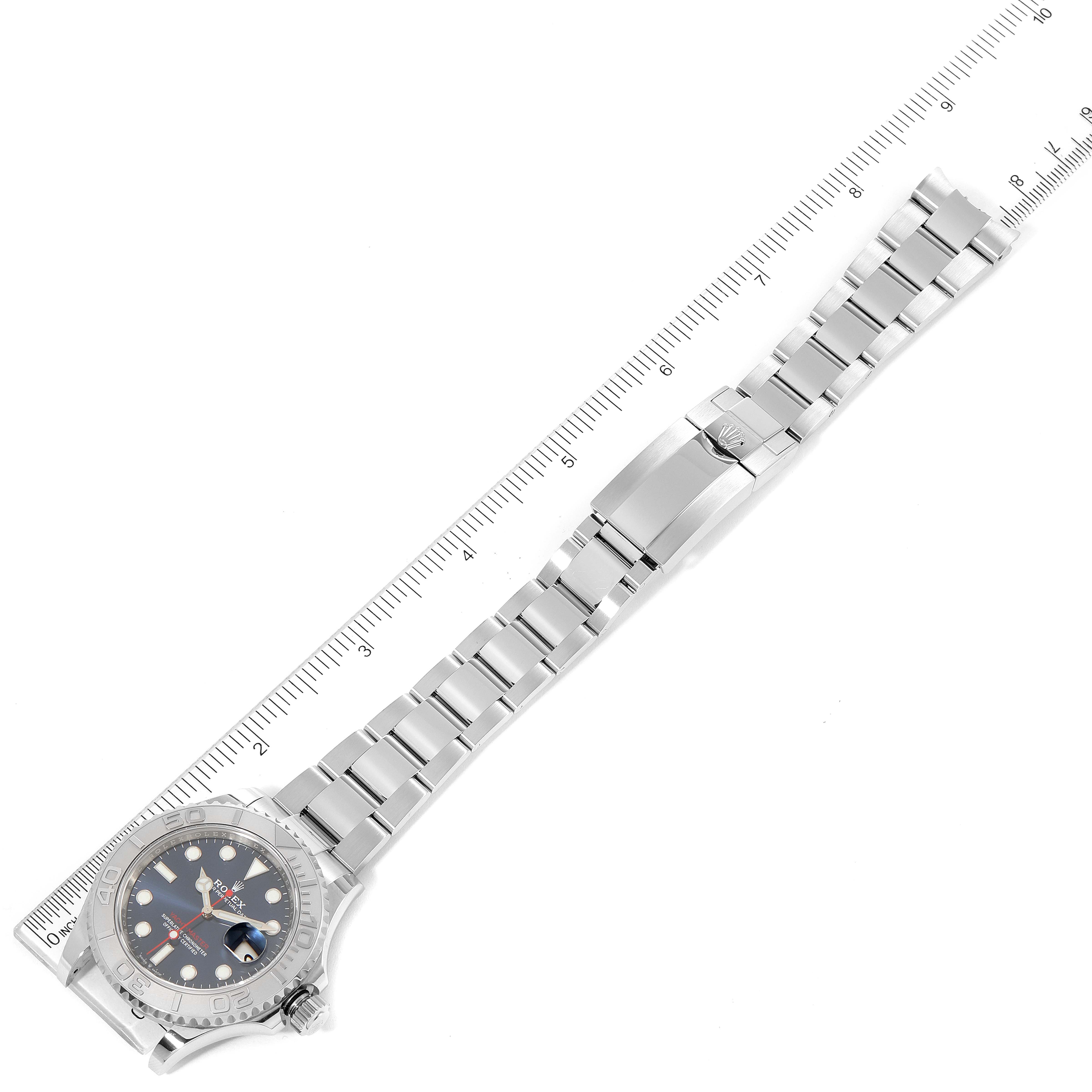 The image shows a Rolex Yacht-Master 126622 Men
s Stainless Steel Blue Dial 126622 Men
s Stainless Steel Blue Dial watch laid flat, displaying the bracelet, clasp, and face, next to a ruler for scale.