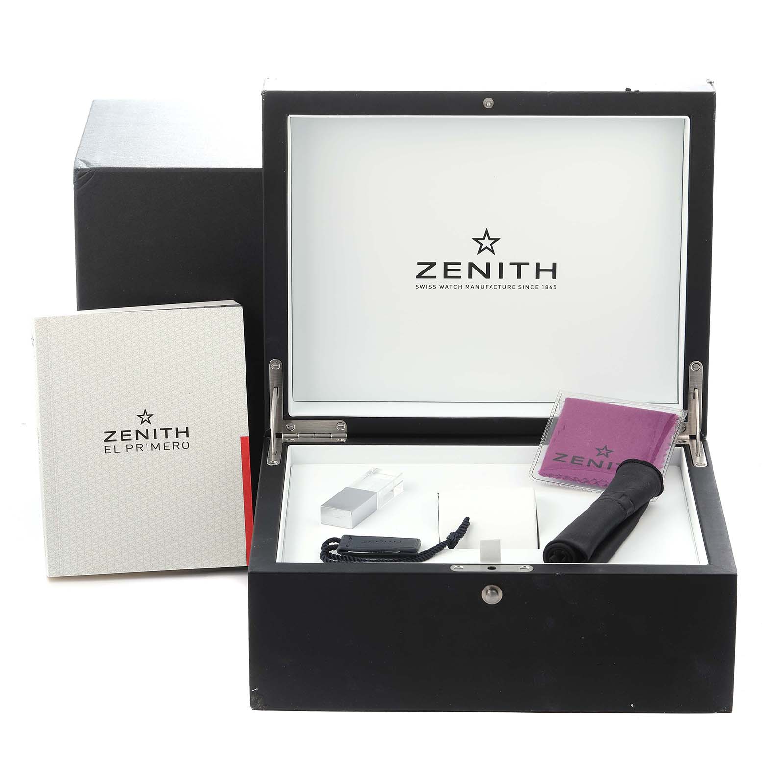 The image shows the open box of a Zenith Chronomaster model 03.A384.400/385.M385 with various accessories including a booklet, cleaning cloth, and a tool.