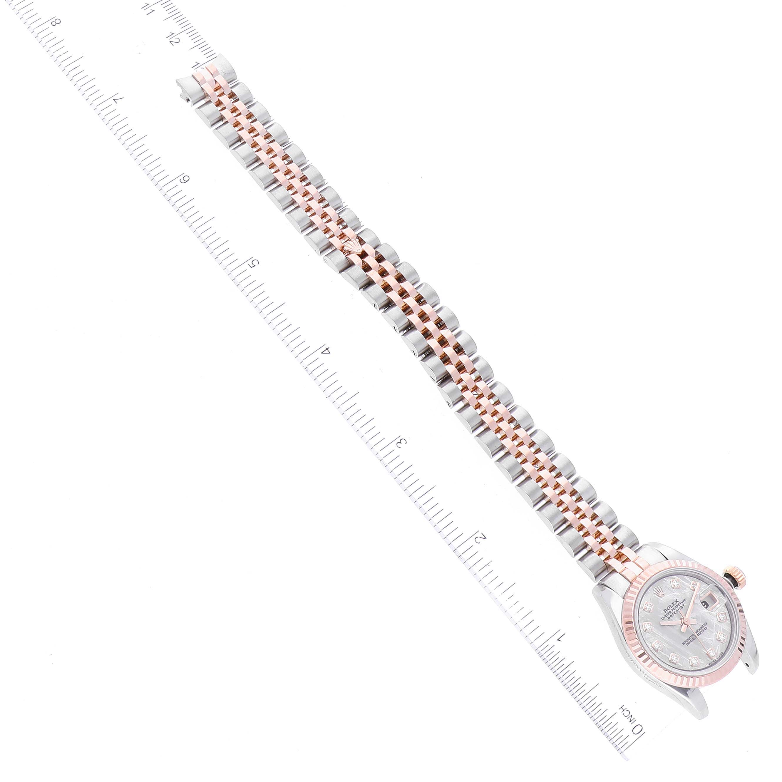 The image shows a top-down view of a Rolex Datejust 179171 Women's Steel and Gold (two tone) Silver Dial 179171 Women's Steel and Gold (two tone) Silver Dial watch, highlighting its face, bracelet, and a measuring ruler for scale.
