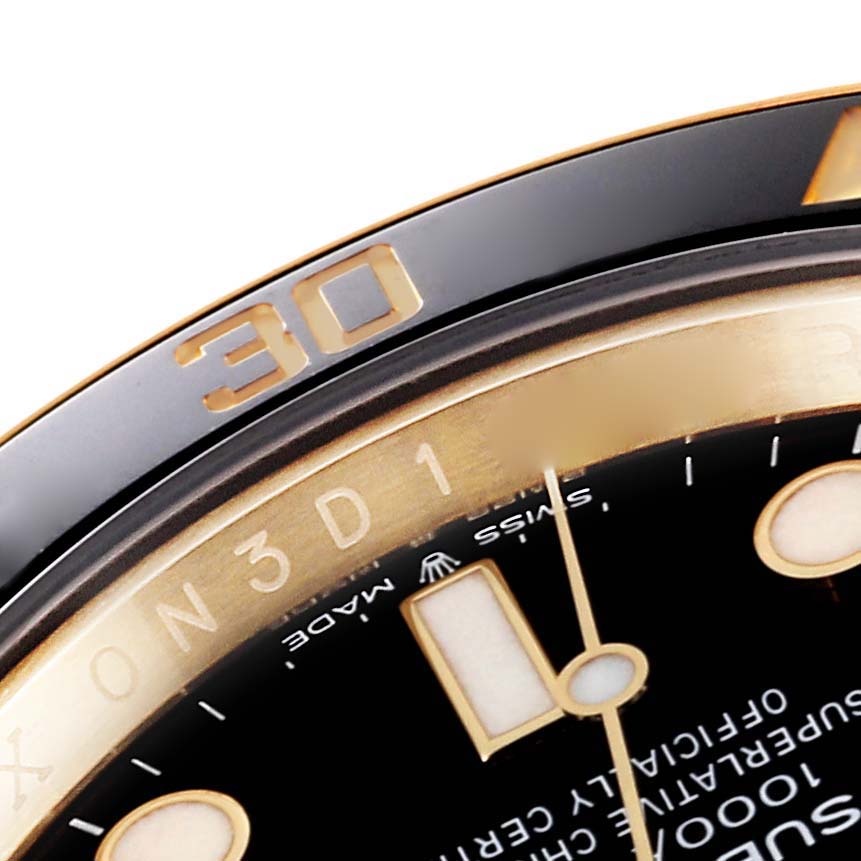 This close-up image of a Rolex Submariner 126618 Men's Yellow Gold Black Dial 126618 Men's Yellow Gold Black Dial shows a portion of the bezel, dial, and hands.