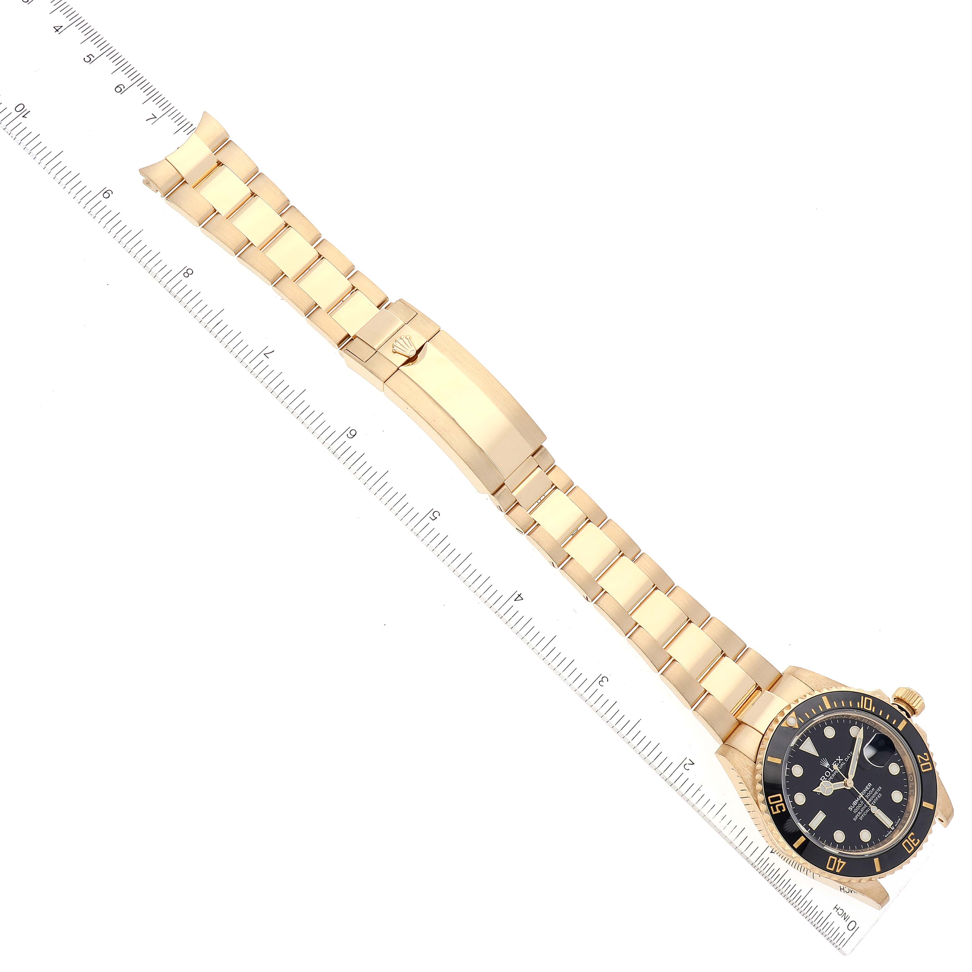 The image shows a Rolex Submariner 126618 Men's Yellow Gold Black Dial 126618 Men's Yellow Gold Black Dial watch laid out flat, showcasing its gold bracelet and clasp alongside a ruler for measurement.
