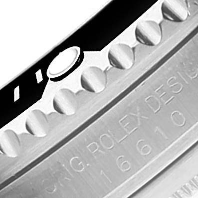 Close-up angle shows the side of a Rolex Submariner 16610 Men
s Stainless Steel Black Dial 16610 Men
s Stainless Steel Black Dial watch with its bezel and engraved model number.