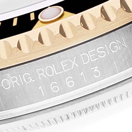 This image shows the engraved model number "16613" and "ORIG. ROLEX DESIGN" on the side case of a Rolex Submariner 16613 Men's Steel and Gold (two tone) Black Dial 16613 Men's Steel and Gold (two tone) Black Dial watch.