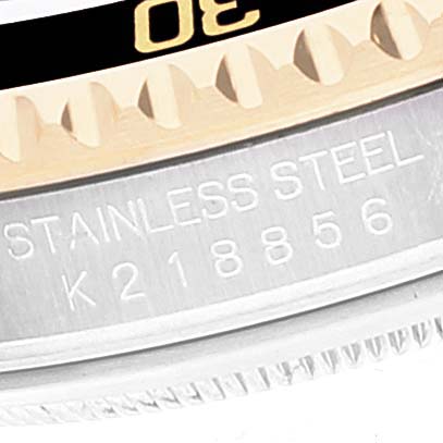 Close-up image of the bezel and case of a Rolex Submariner 16613 Men's Steel and Gold (two tone) Black Dial 16613 Men's Steel and Gold (two tone) Black Dial watch, showing part of the rotating bezel and serial number.