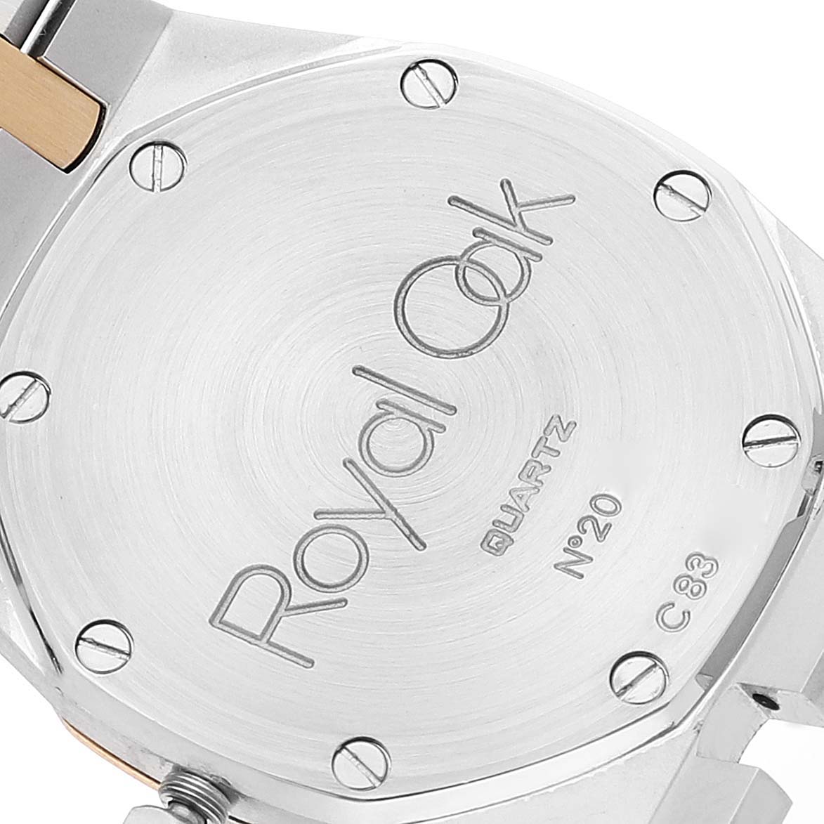 The image shows the back case of an Audemars Piguet Royal Oak 56303SA Women's Steel and Gold (two tone) Champagne Dial 56303SA Women's Steel and Gold (two tone) Champagne Dial watch, featuring engraved text and screws.