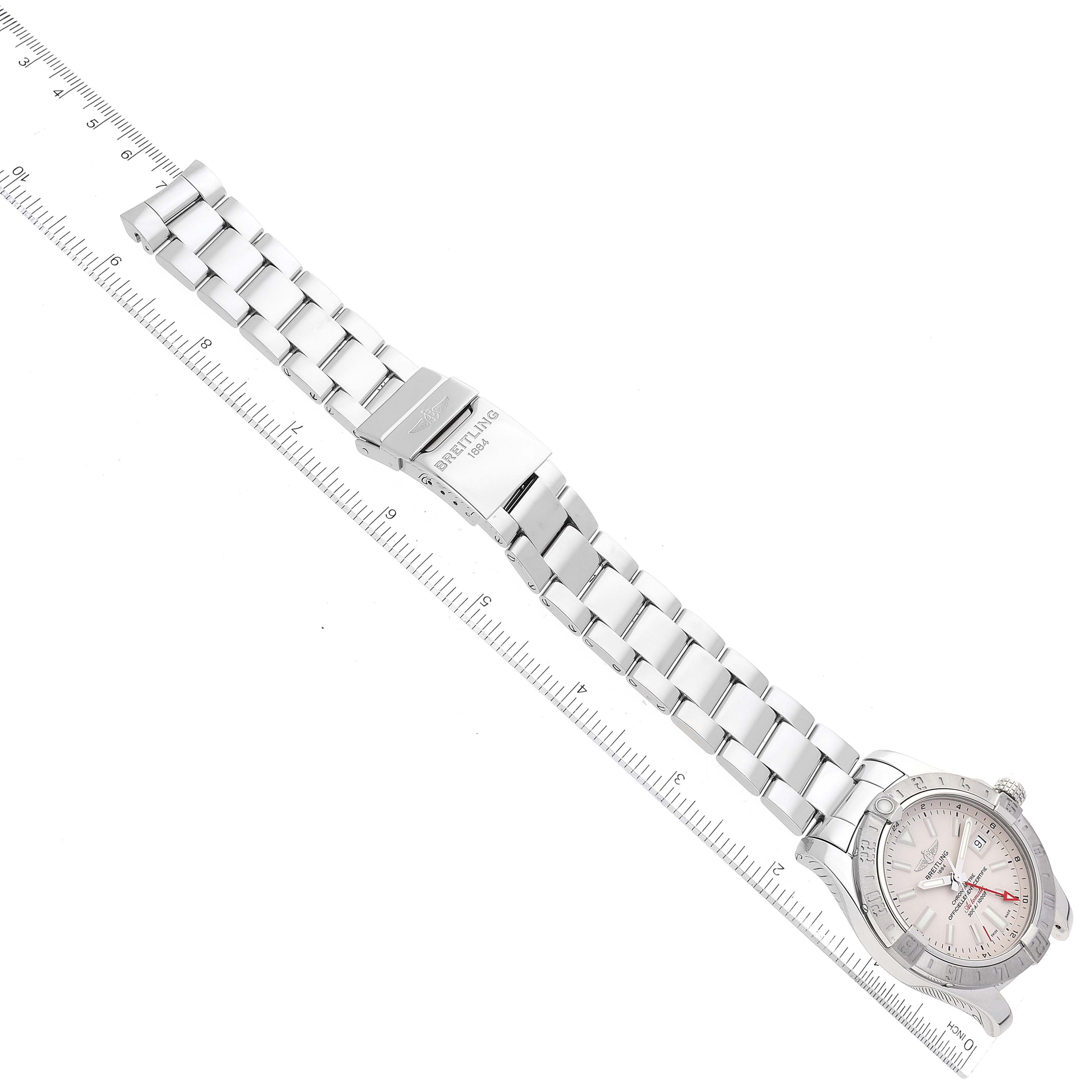 The image shows a top-down view of a Breitling Avenger A32390 Men's Stainless Steel Beige Dial A32390 Men's Stainless Steel Beige Dial watch with its metal bracelet fully extended next to a ruler.