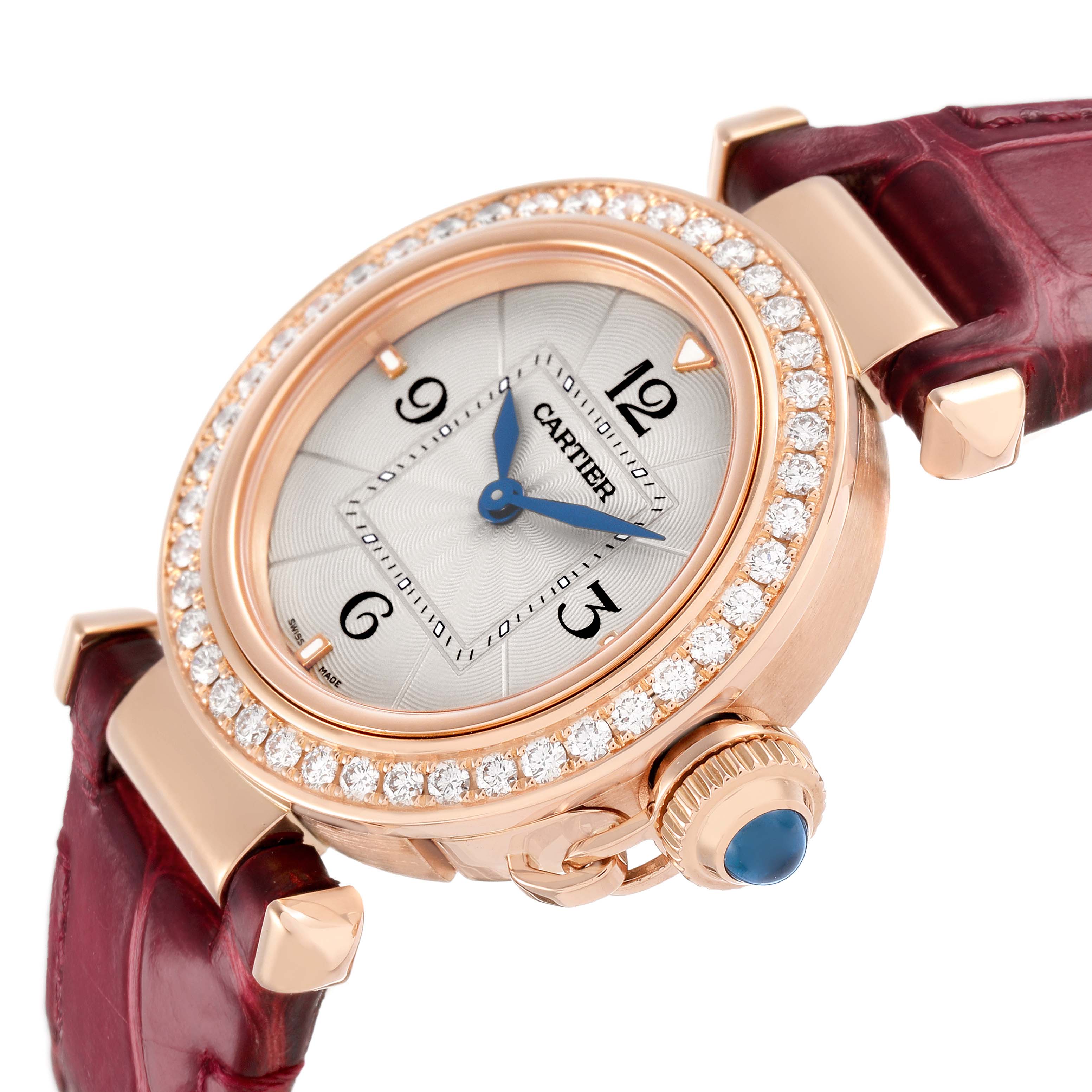The Cartier Pasha WJPA0017 Women's Rose Gold White Dial watch is shown from a three-quarter angle emphasizing its diamond bezel, crown, and maroon strap.