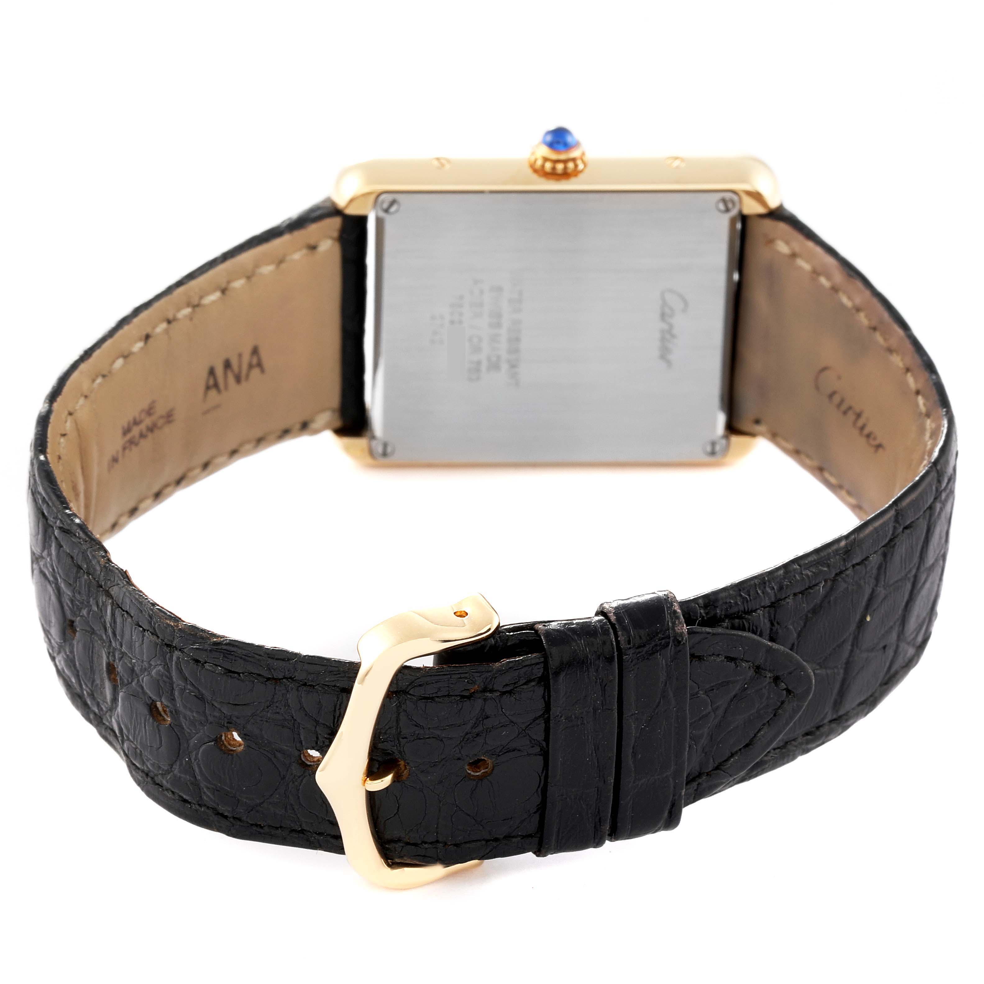 The image shows the back view of a Cartier Tank Solo W1018855 Men
s Yellow Gold Silver Dial W1018855 Men
s Yellow Gold Silver Dial watch, highlighting its clasp, leather strap, and case back.