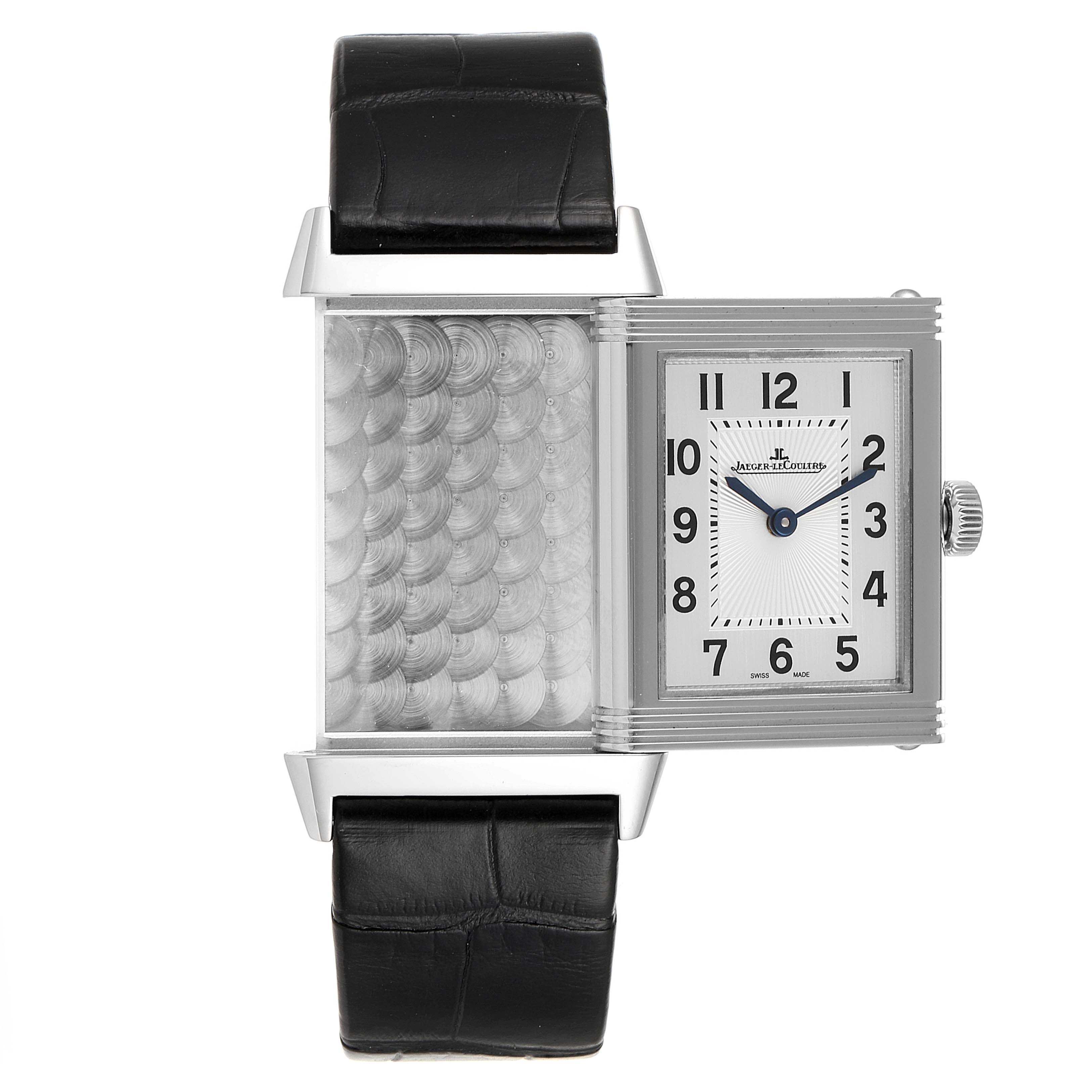 The image shows a Jaeger-LeCoultre Reverso watch with its reversible case displayed, highlighting the inner decoration and dial.