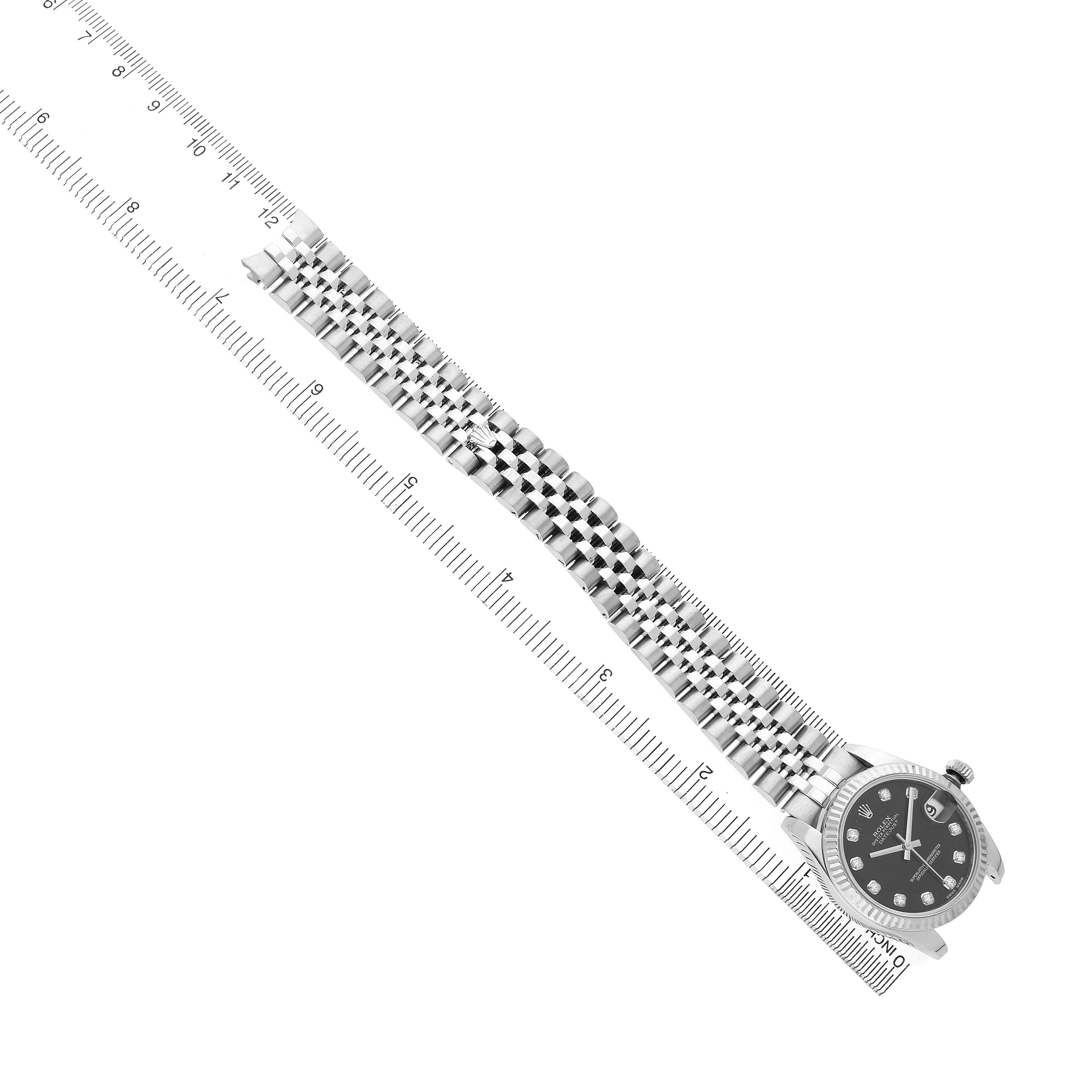 The Rolex Mid-Size 178274 Women's Stainless Steel Black Dial watch is shown from a top view, highlighting the full bracelet and face with a ruler alongside for scale.