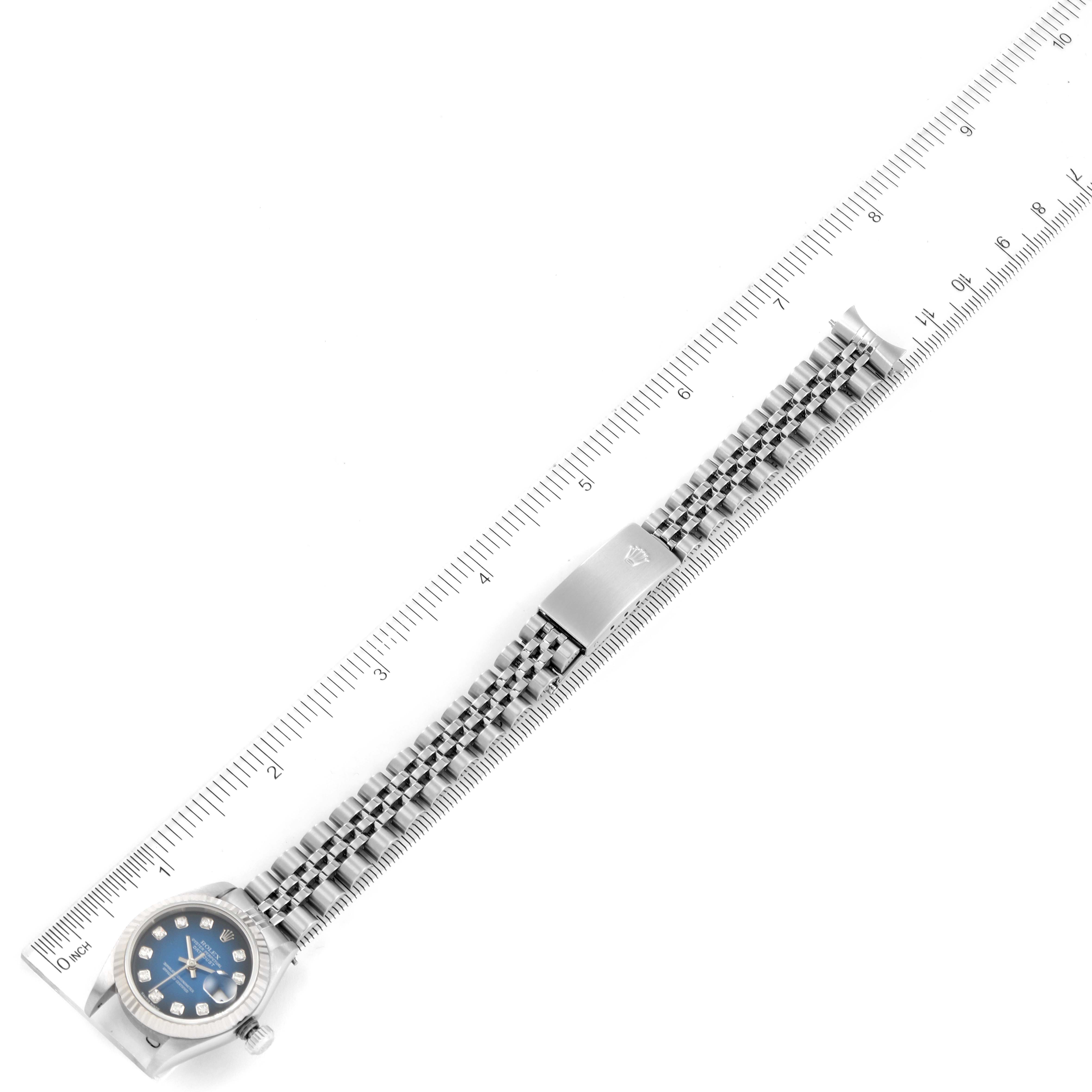 The image shows a Rolex Datejust 79174 Women's Stainless Steel Blue Dial 79174 Women's Stainless Steel Blue Dial watch lying flat with its full bracelet extended alongside a ruler for scale.