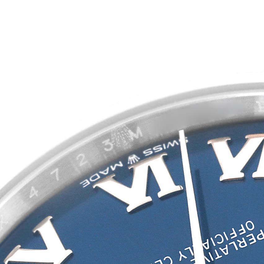 The image shows a close-up of the Mid-Size Rolex watch face, focusing on the dial and a part of the bezel.