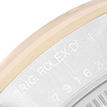 Close-up of the edge of a Rolex Datejust 79163 Women's Steel and Gold (two tone) Silver Dial 79163 Women's Steel and Gold (two tone) Silver Dial watch case, showing the engraved model number and "ORIG. ROLEX DESIGN."