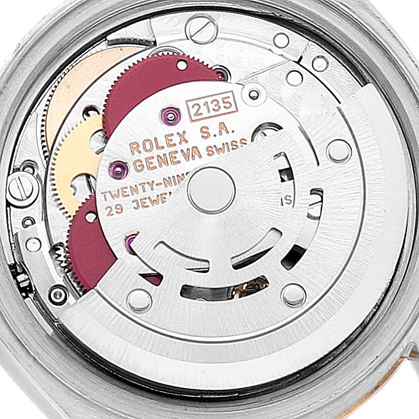 The image shows a close-up of the movement mechanism inside a Rolex Datejust 69173 Women's Steel and Gold (two tone) Silver Dial 69173 Women's Steel and Gold (two tone) Silver Dial watch, highlighting gears and text engravings.