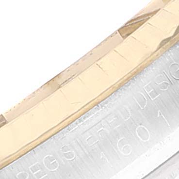 This close-up image shows the side view of the bezel and part of the casing with engravings of a Rolex Datejust 1601 Men
s Steel and Gold (two tone) Champagne Dial 1601 Men
s Steel and Gold (two tone) Champagne Dial.
