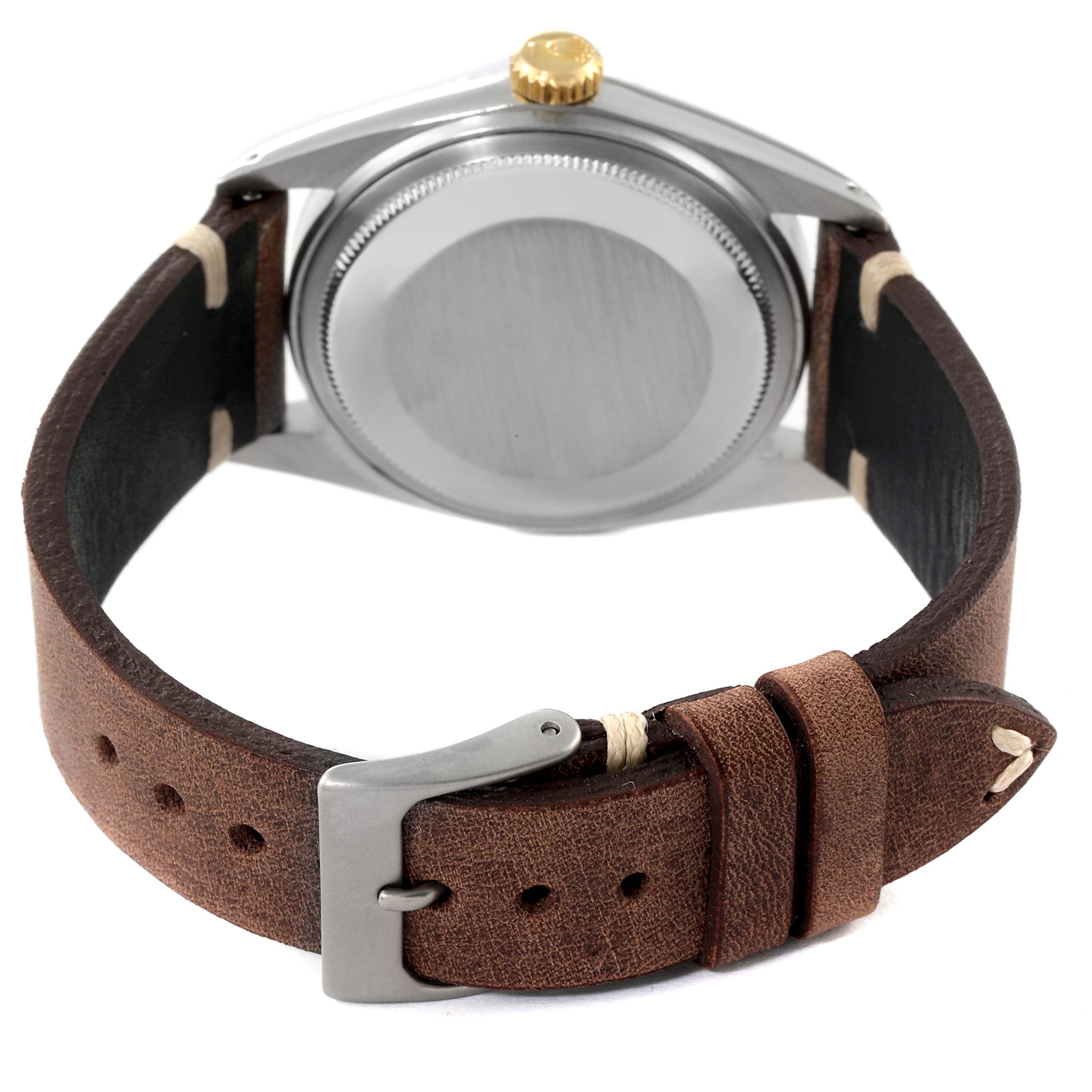 This image shows the back view of a Rolex Datejust 1601 Men
s Steel and Gold (two tone) Champagne Dial 1601 Men
s Steel and Gold (two tone) Champagne Dial watch with a brown leather strap and a closed buckle.
