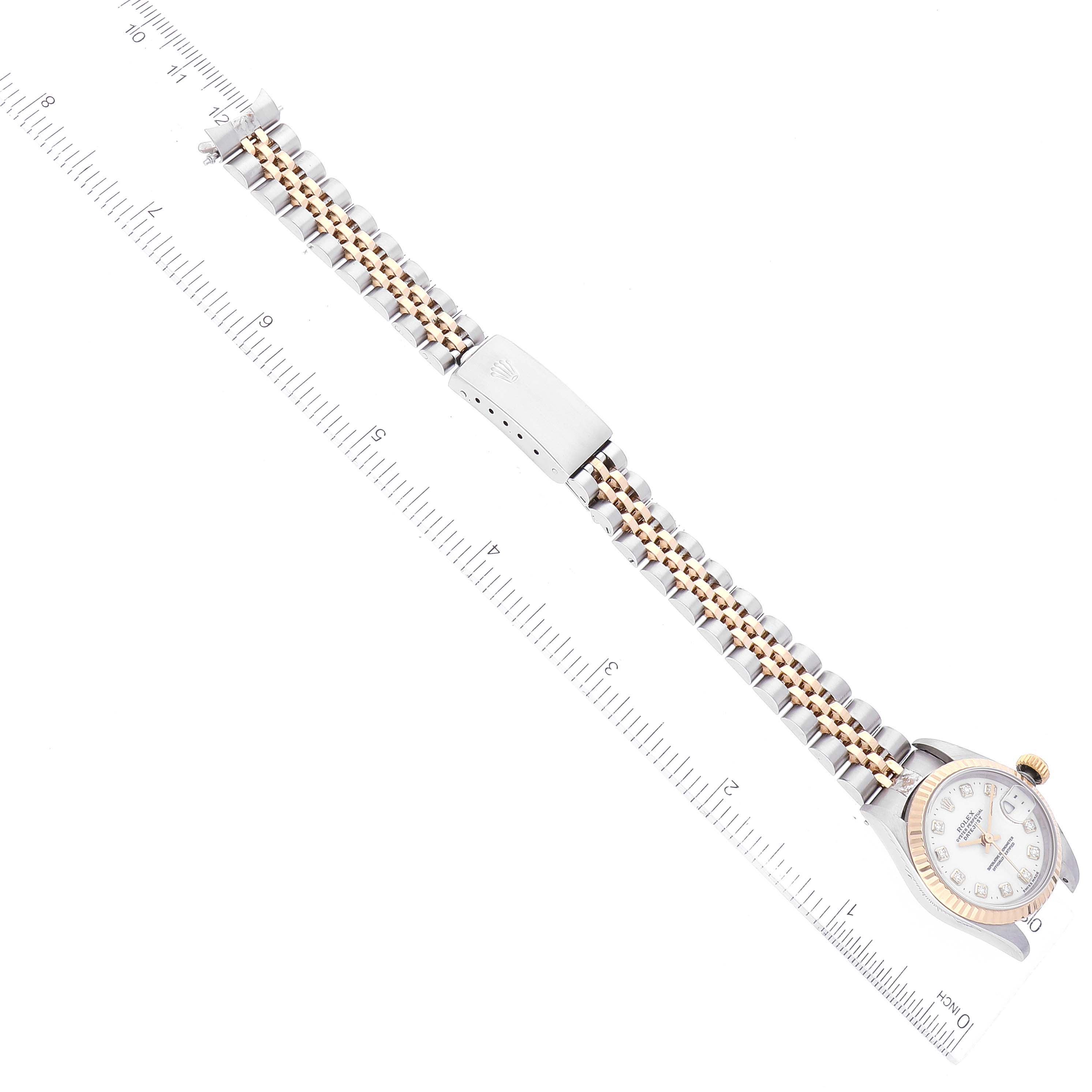 This image shows a Rolex Datejust 69173 Women's Steel and Gold (two tone) White Dial 69173 Women's Steel and Gold (two tone) White Dial from a top-down angle, highlighting the watch face, band, and clasp against a ruler.