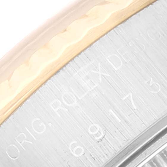 Close-up of the edge of a Rolex Datejust 69173 Women's Steel and Gold (two tone) White Dial 69173 Women's Steel and Gold (two tone) White Dial watch case showing engraved text and the rim details.